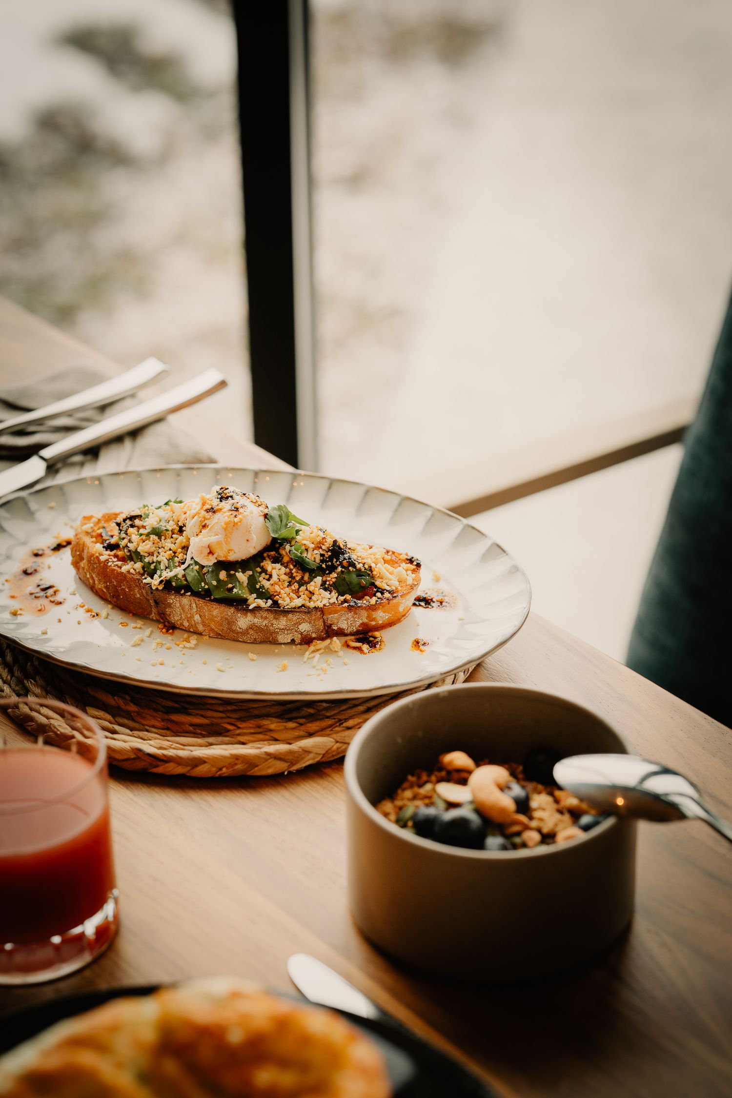 Elegant plated dishes and beverages on a wooden table in natural lighting.