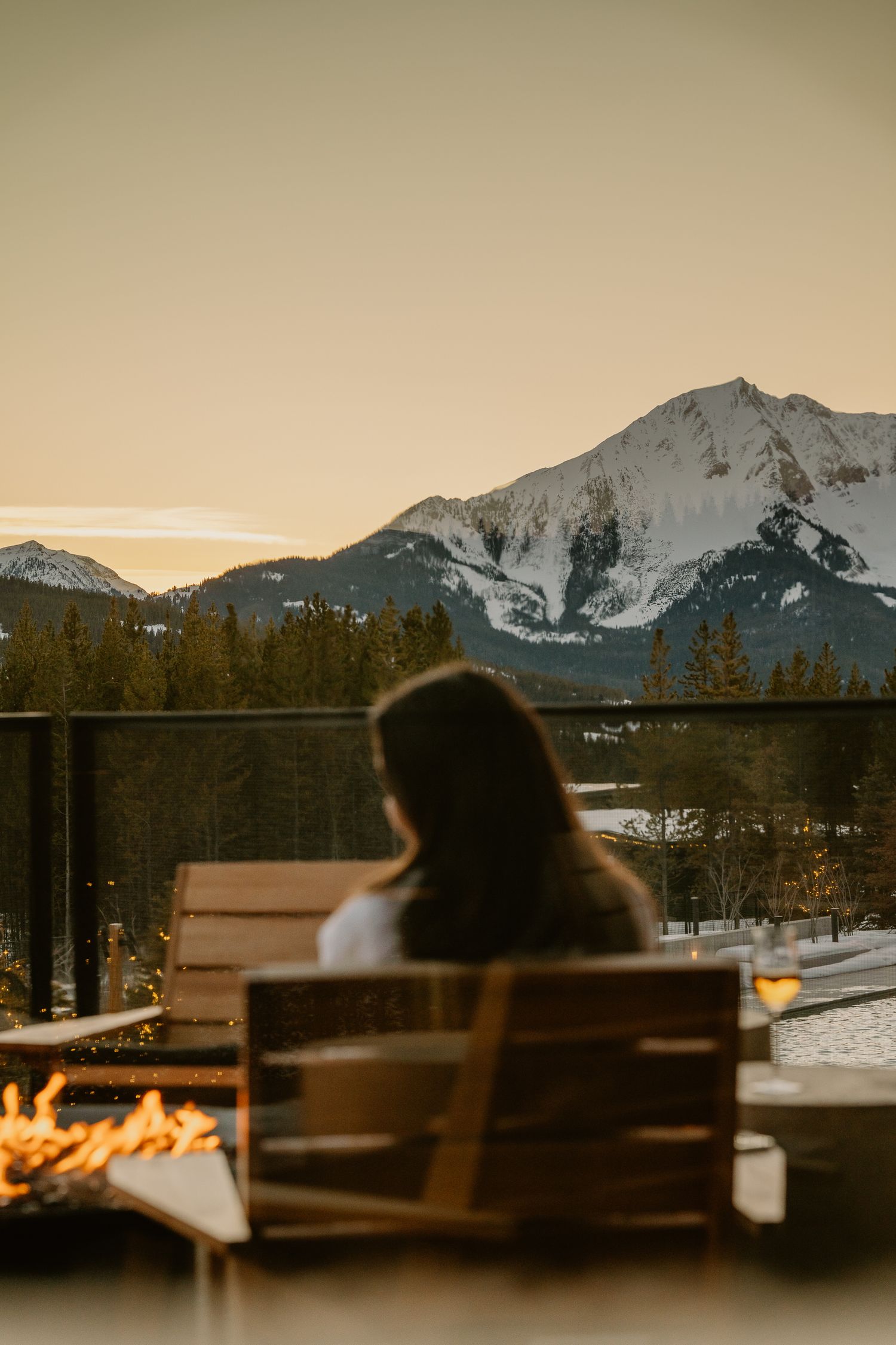 Cozy fireside seating area with stunning mountain views at sunset.