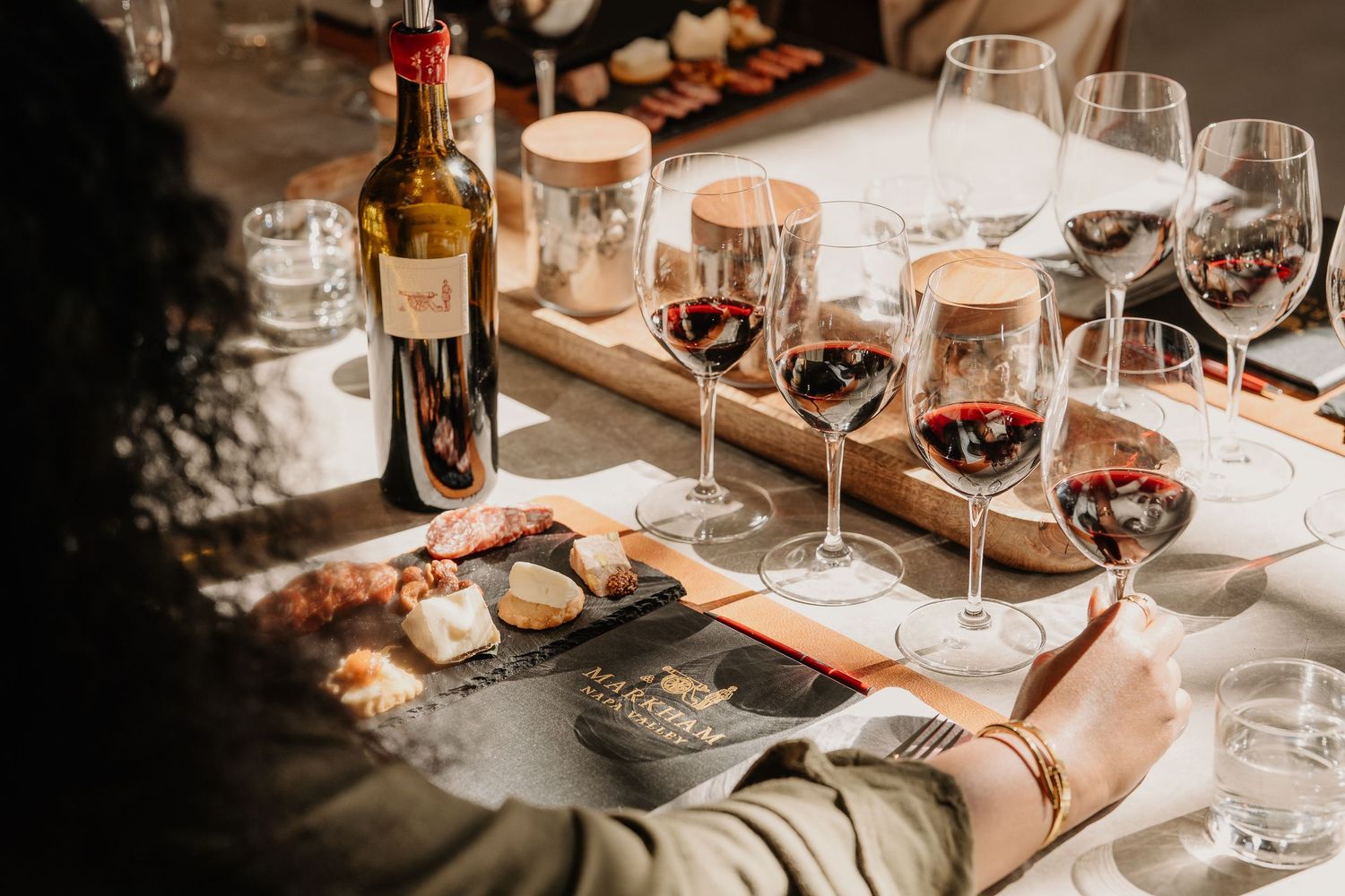 Elegant red wine tasting setup with multiple glasses, charcuterie board, and wine bottle.