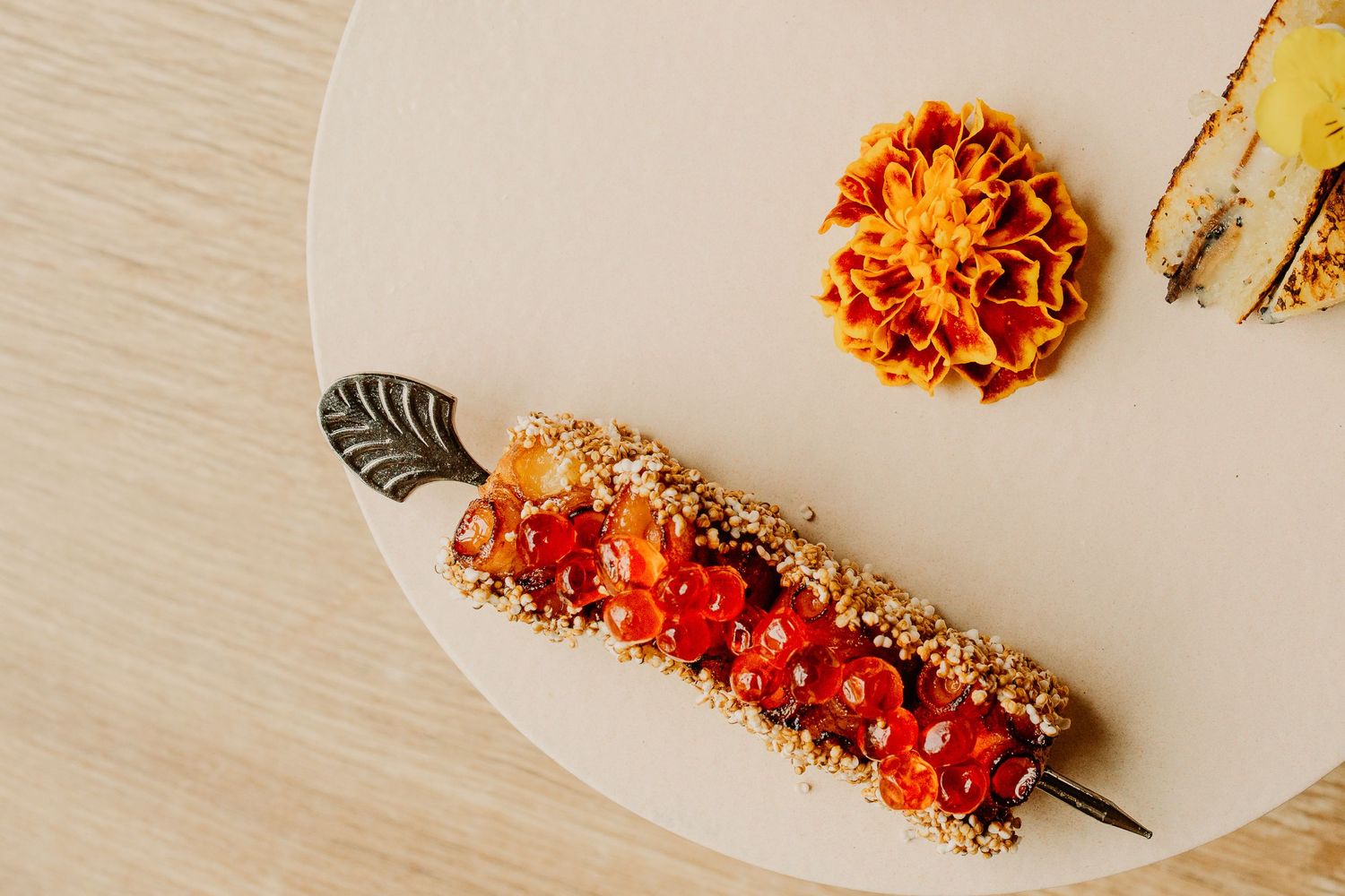 A series of plated appetizers with crispy breaded shrimp and dipping sauce arranged in a row on a wooden surface.