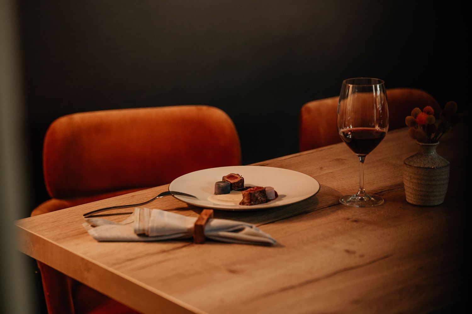 Elegant table setting with wine glasses and plates in a dimly lit restaurant atmosphere.