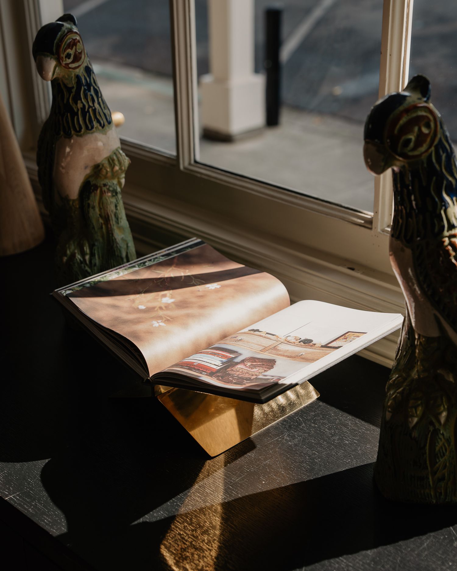 Sunlight streams across a table creating dramatic shadows in a cozy reading nook.