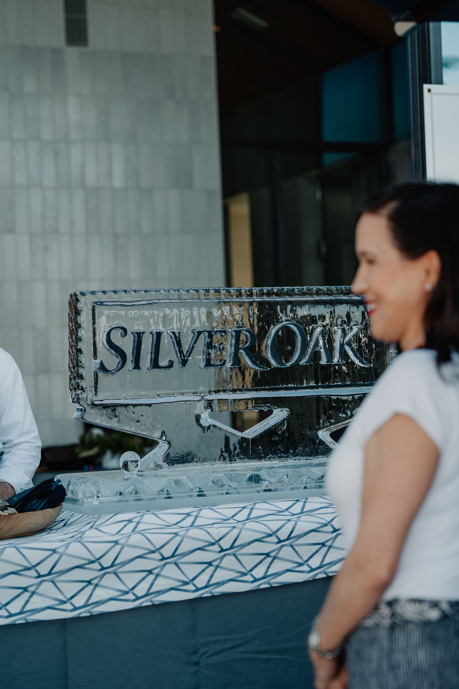 Silver Oak winery ice sculpture logo display at an outdoor event with guests in the background.