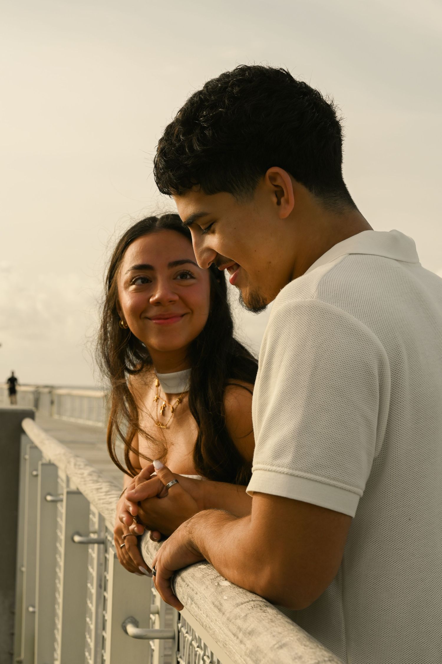 Couple sharing intimate moments against coastal cityscape backdrop.