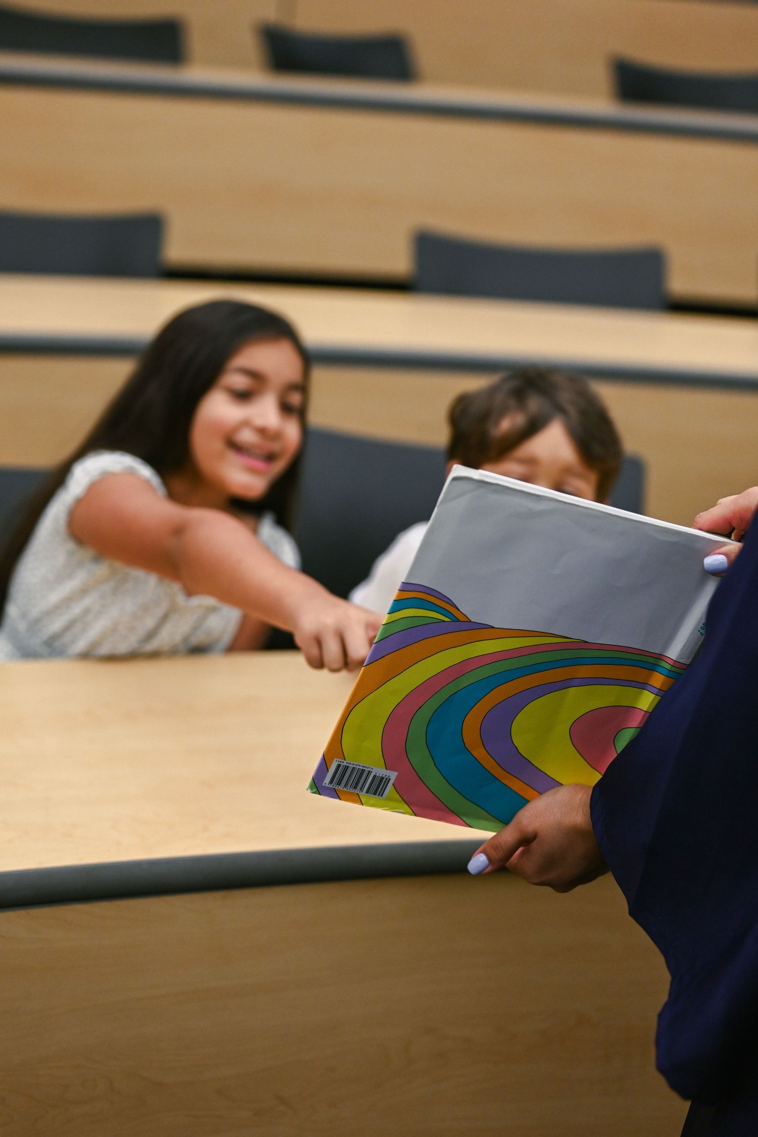 Colorful rainbow artwork being shared across a wooden table.
