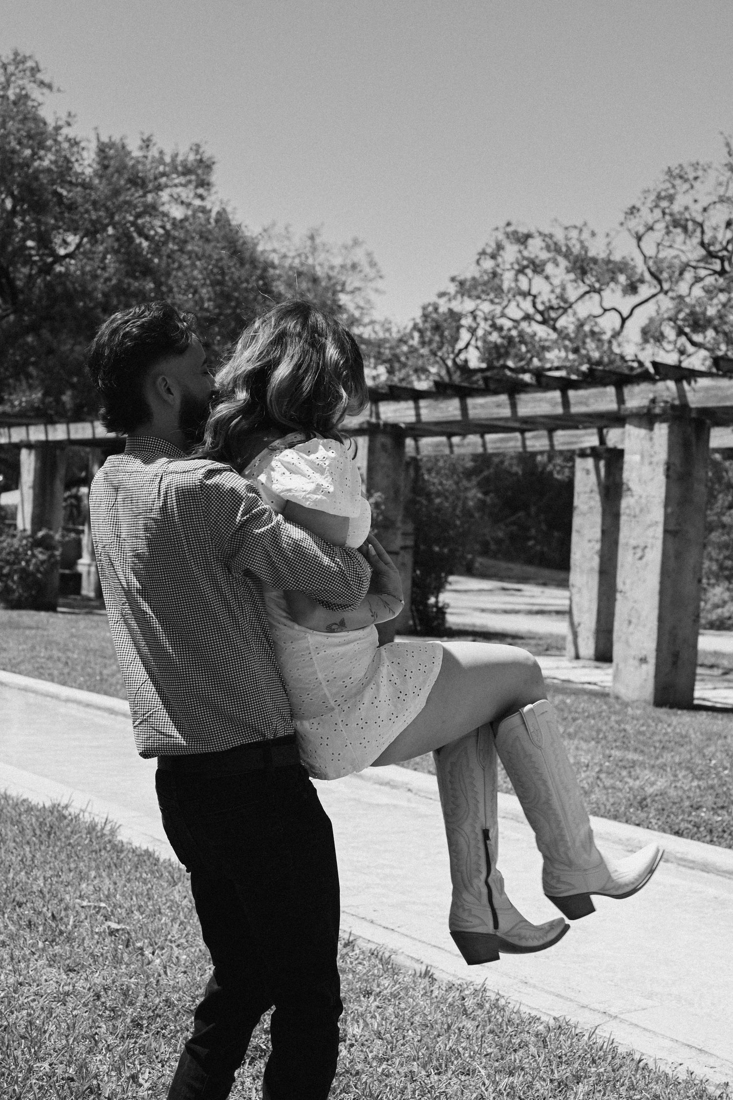 A romantic black and white photo sequence of a couple dancing in a park setting.