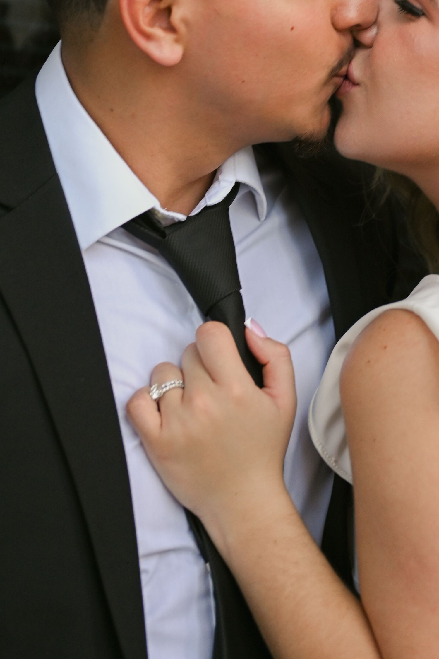 Romantic wedding couple sharing an intimate kiss in formal attire.