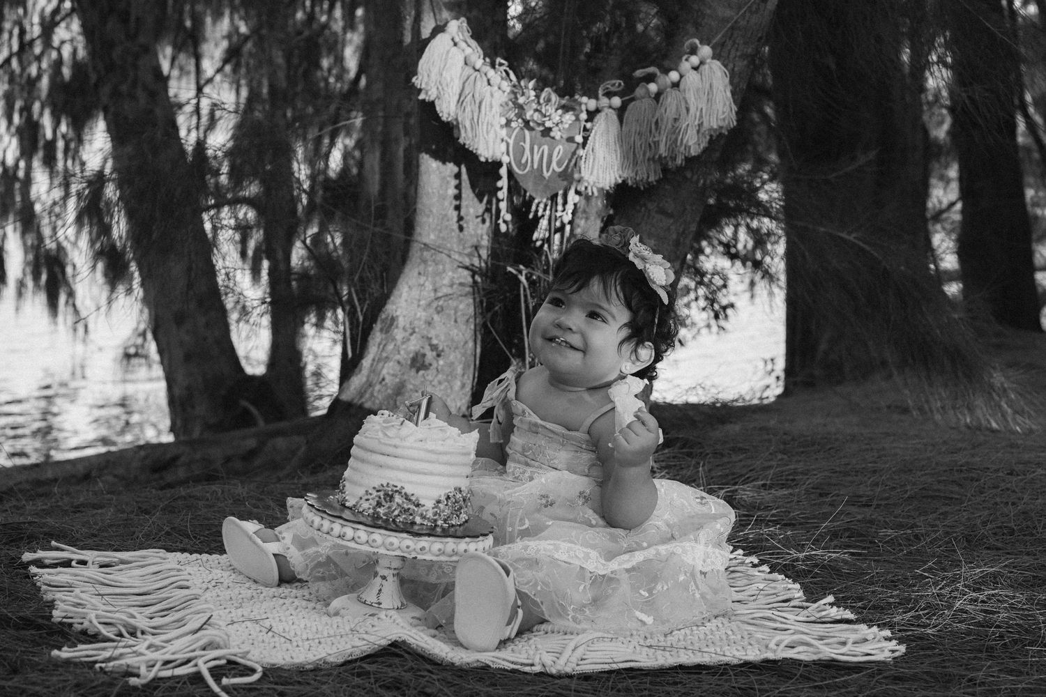 Black and white portrait sequence showing tender family moments in a wooded setting.