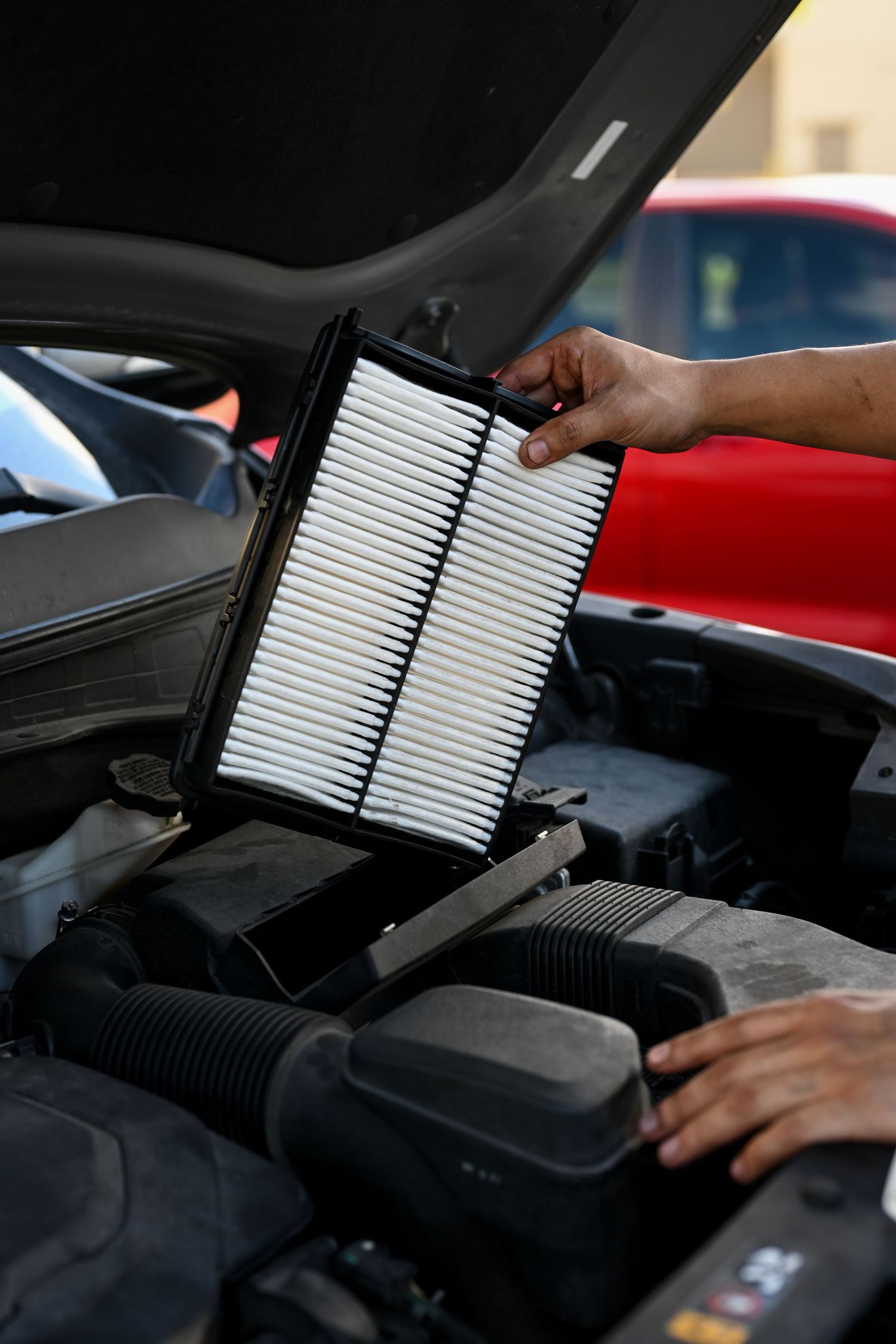 Air filter replacement being performed during car maintenance service.