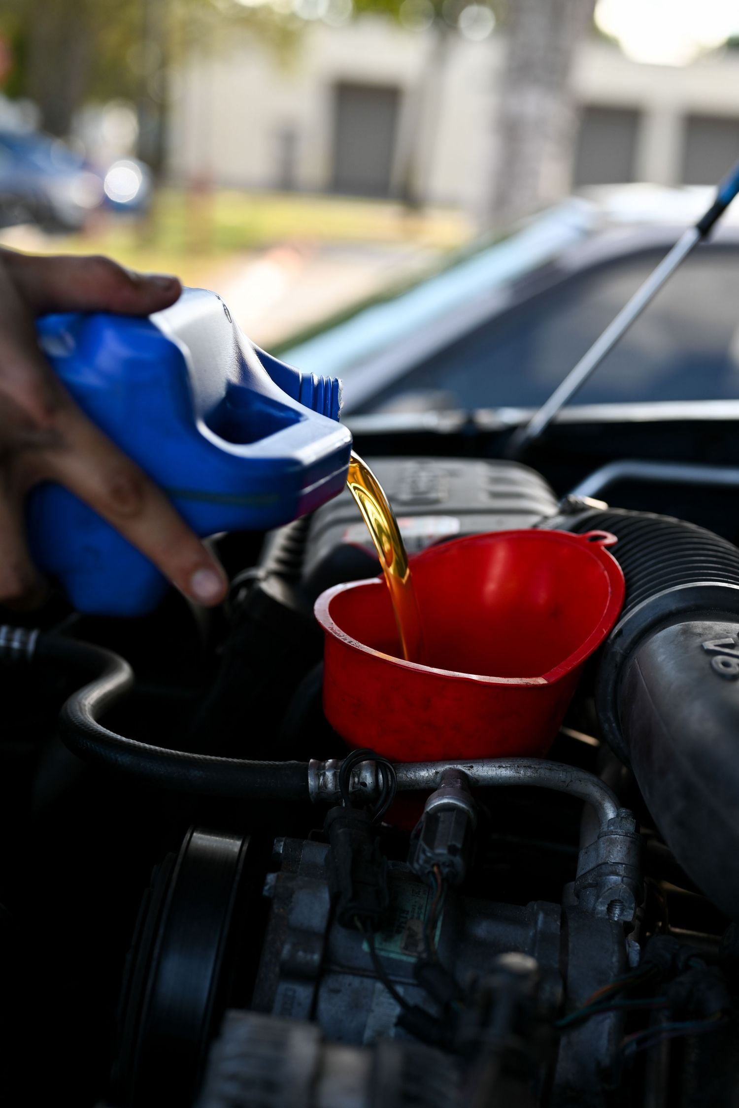 Motor oil being poured into engine during maintenance service.