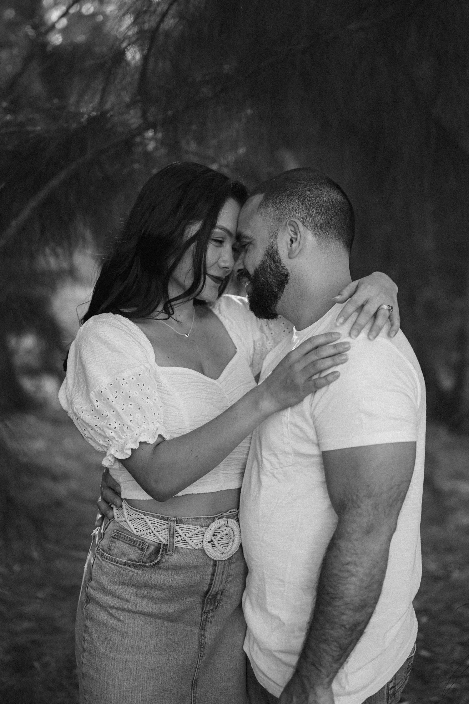 Black and white intimate family portrait showing tender moments outdoors.