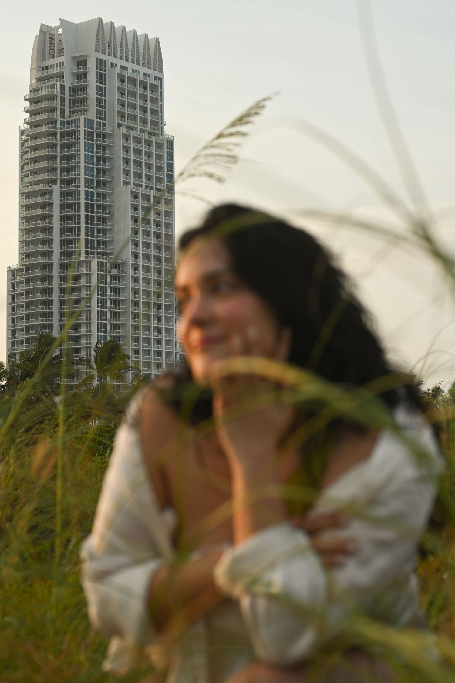 Figure in white shirt poses with tall buildings visible in background.