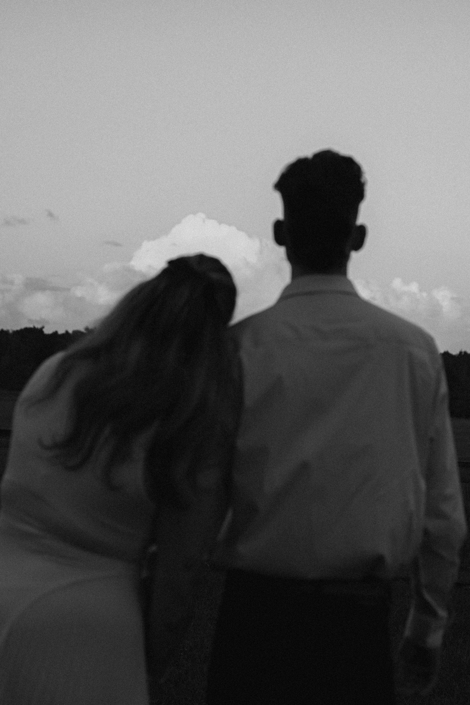 Black and white silhouette of a couple walking together at dusk.