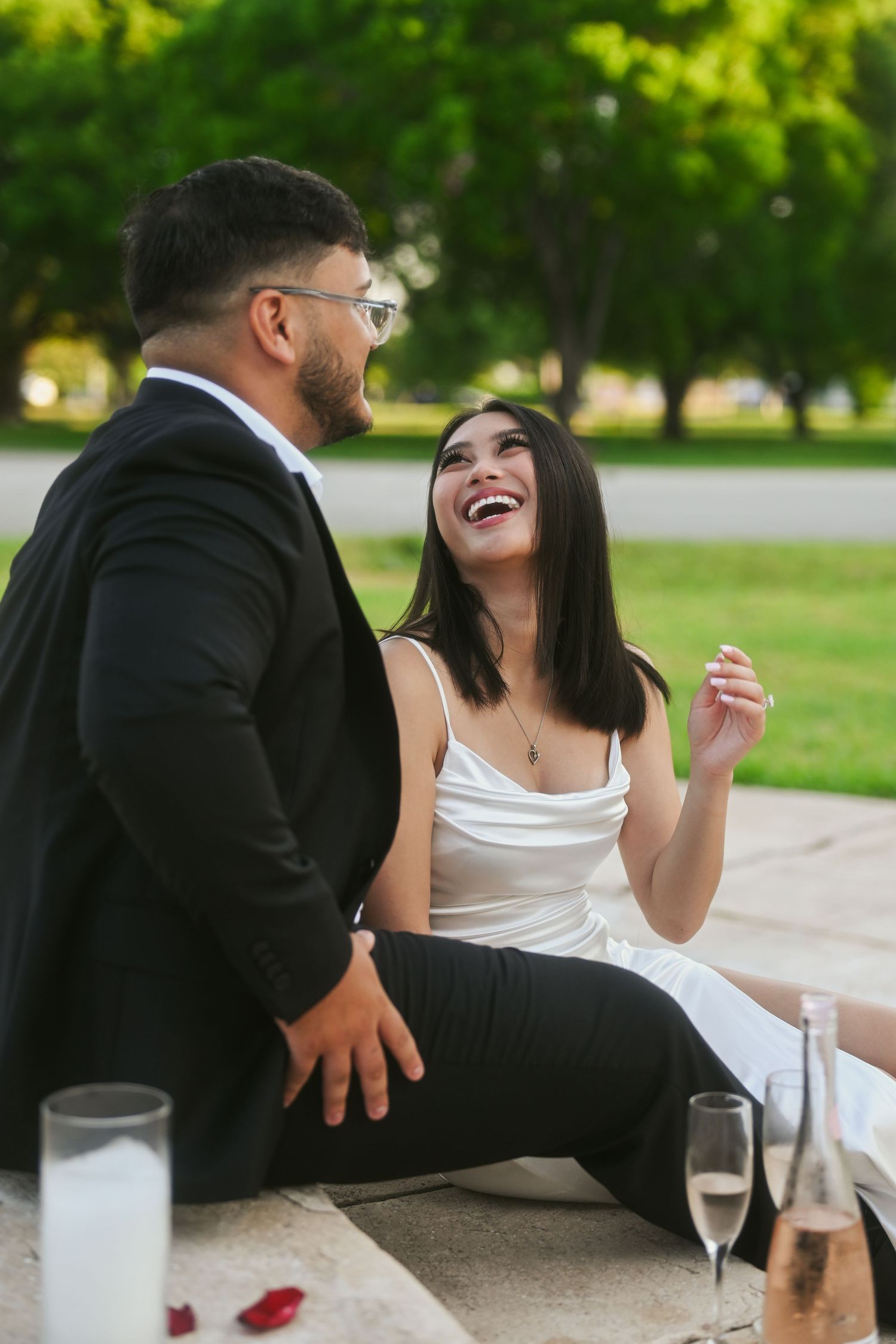 Playful moments captured between couple enjoying drinks outdoors.