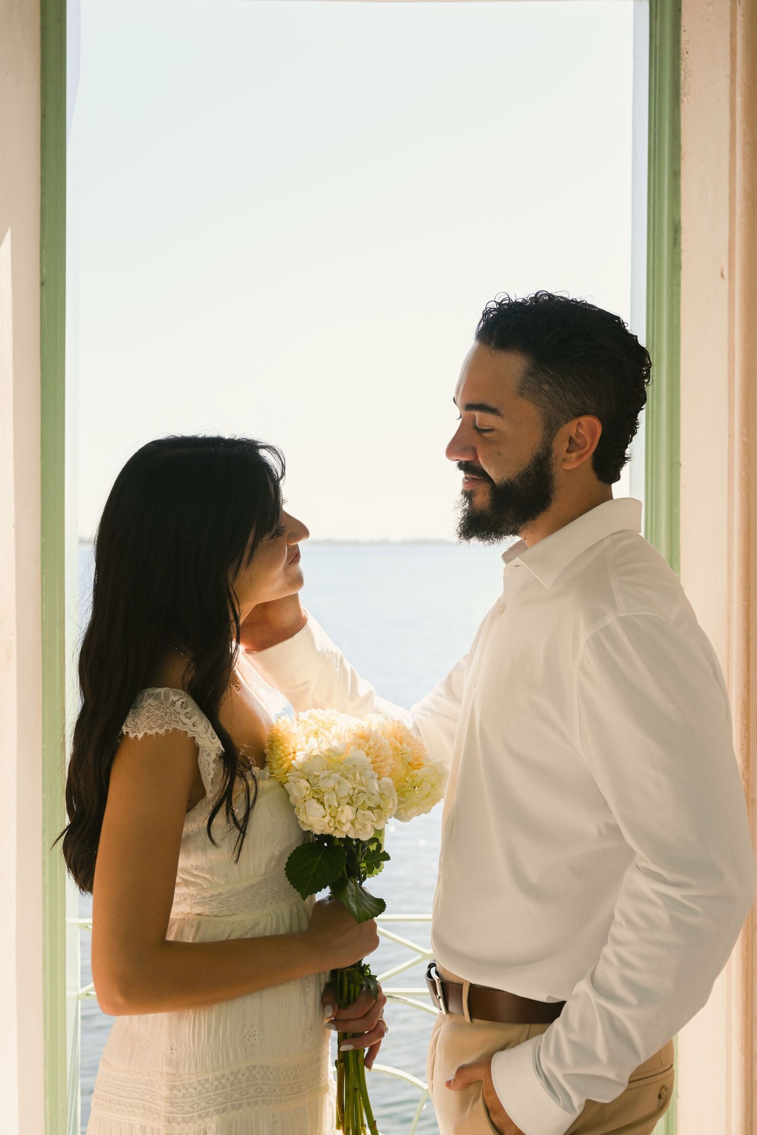 A romantic sequence of tender moments between a couple by sunlit windows.