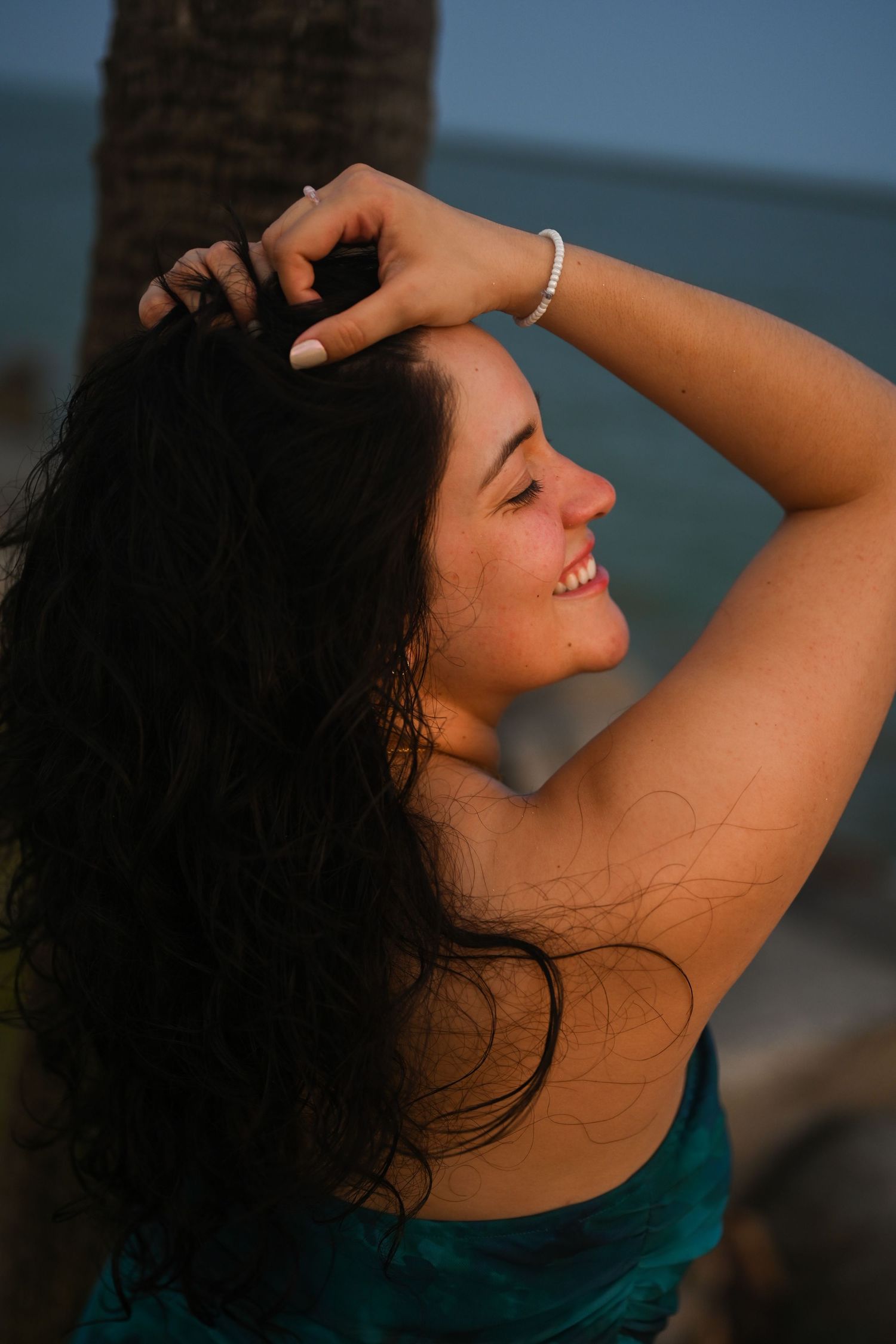 A series of artistic portraits showing a person with dark curly hair in a teal top against a blurred background.