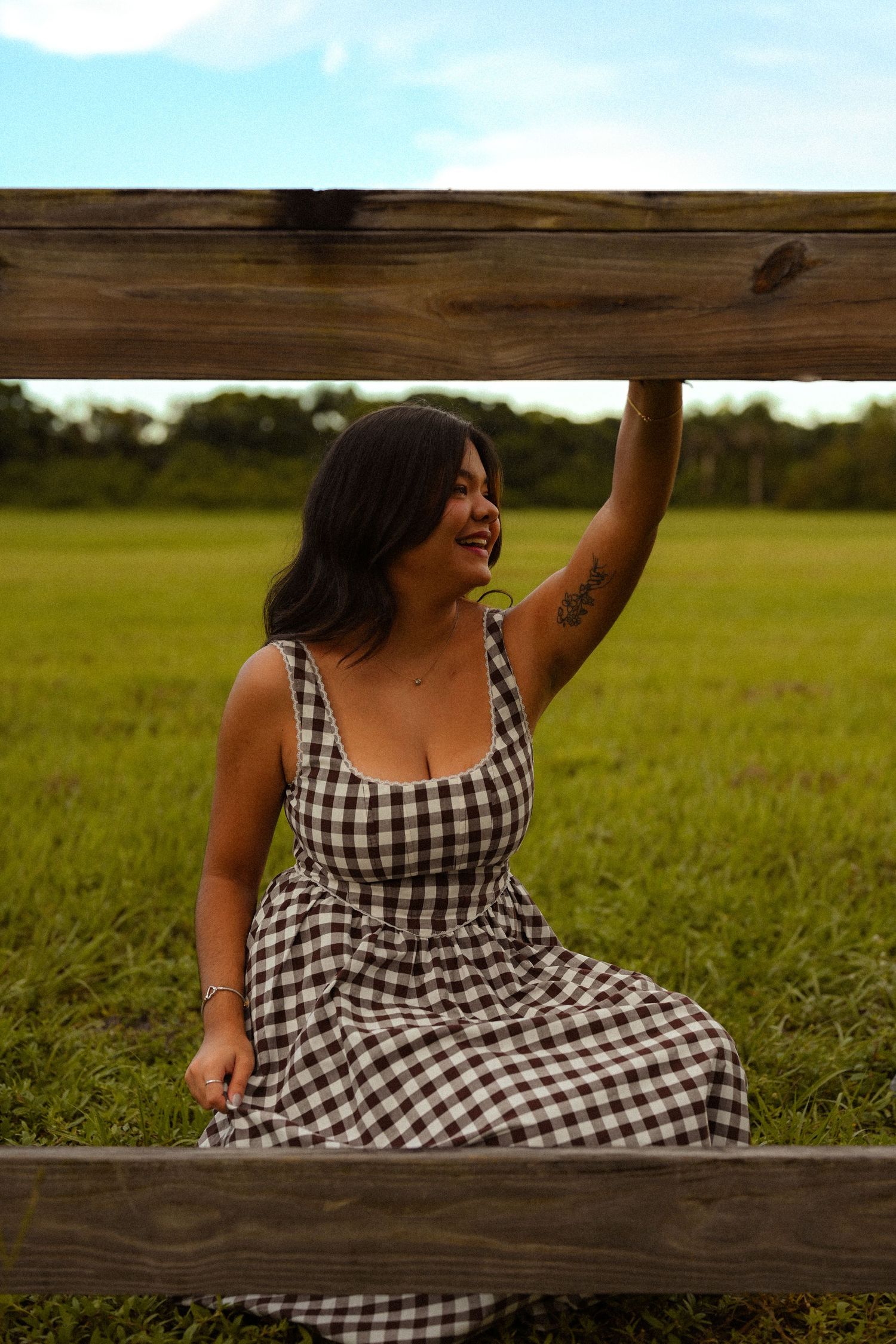 A playful moment captured on a wooden fence surrounded by lush green fields.