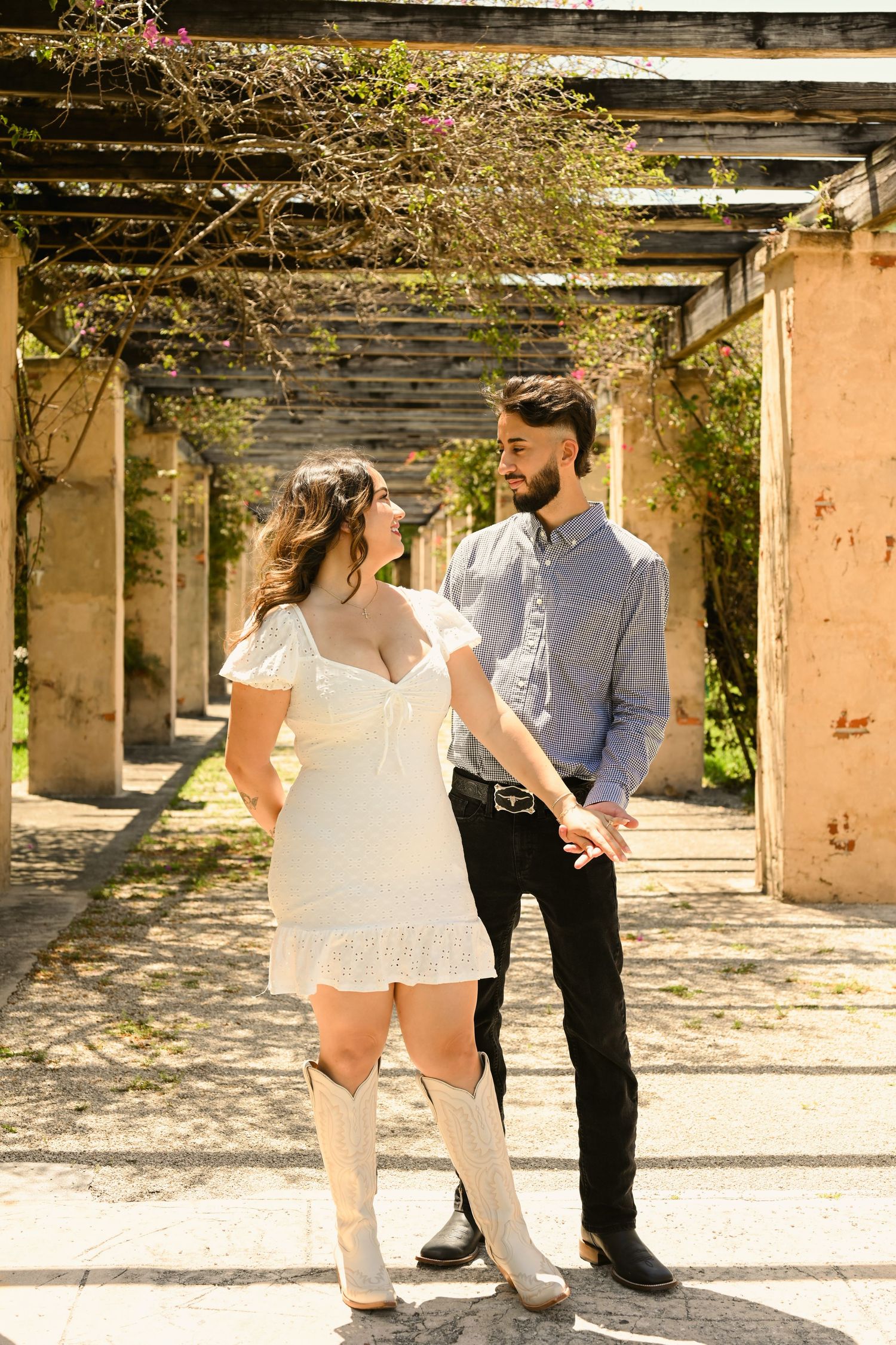 Couple dances and laughs together under a rustic covered walkway.
