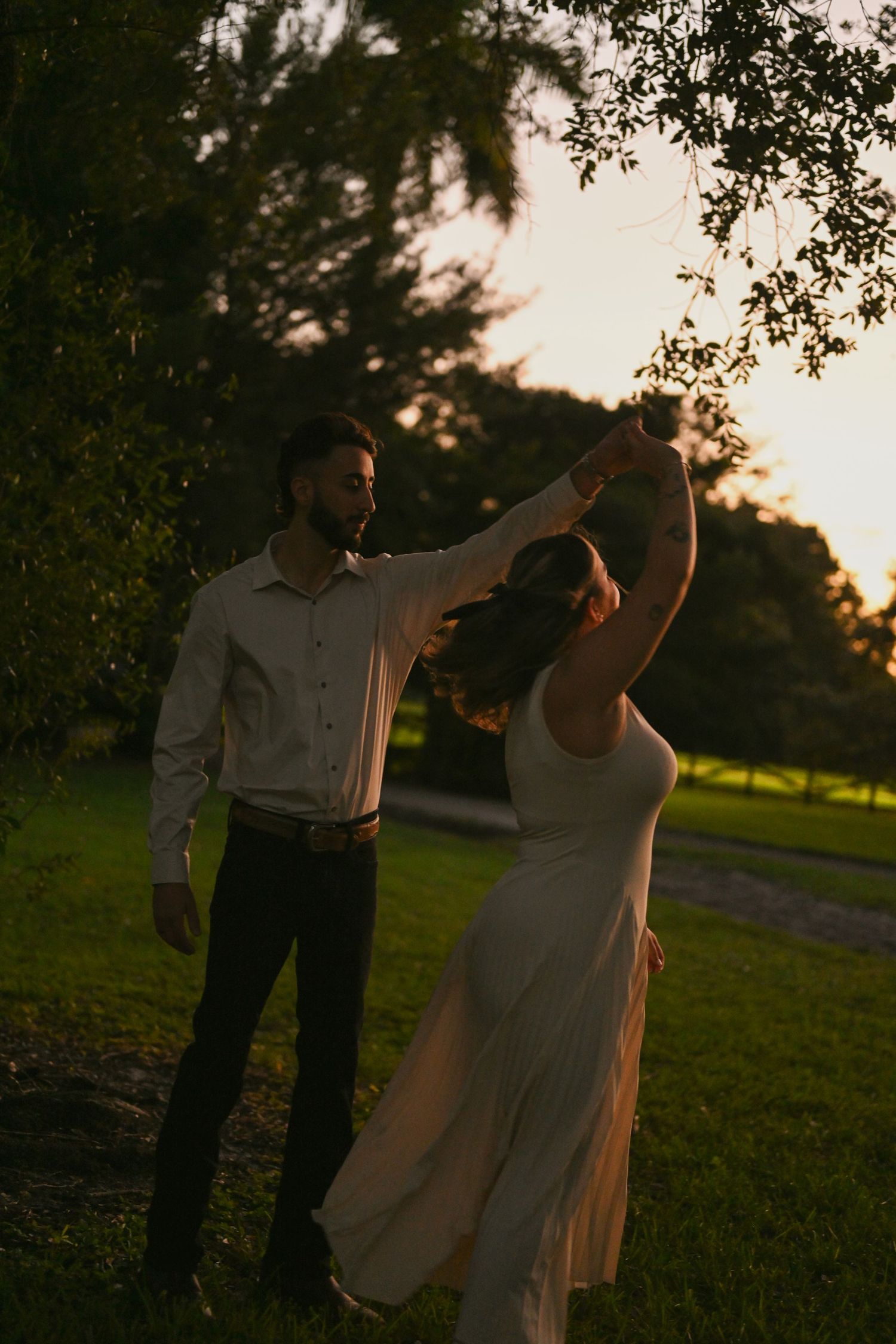 Dancing together in a park during golden hour sunset.
