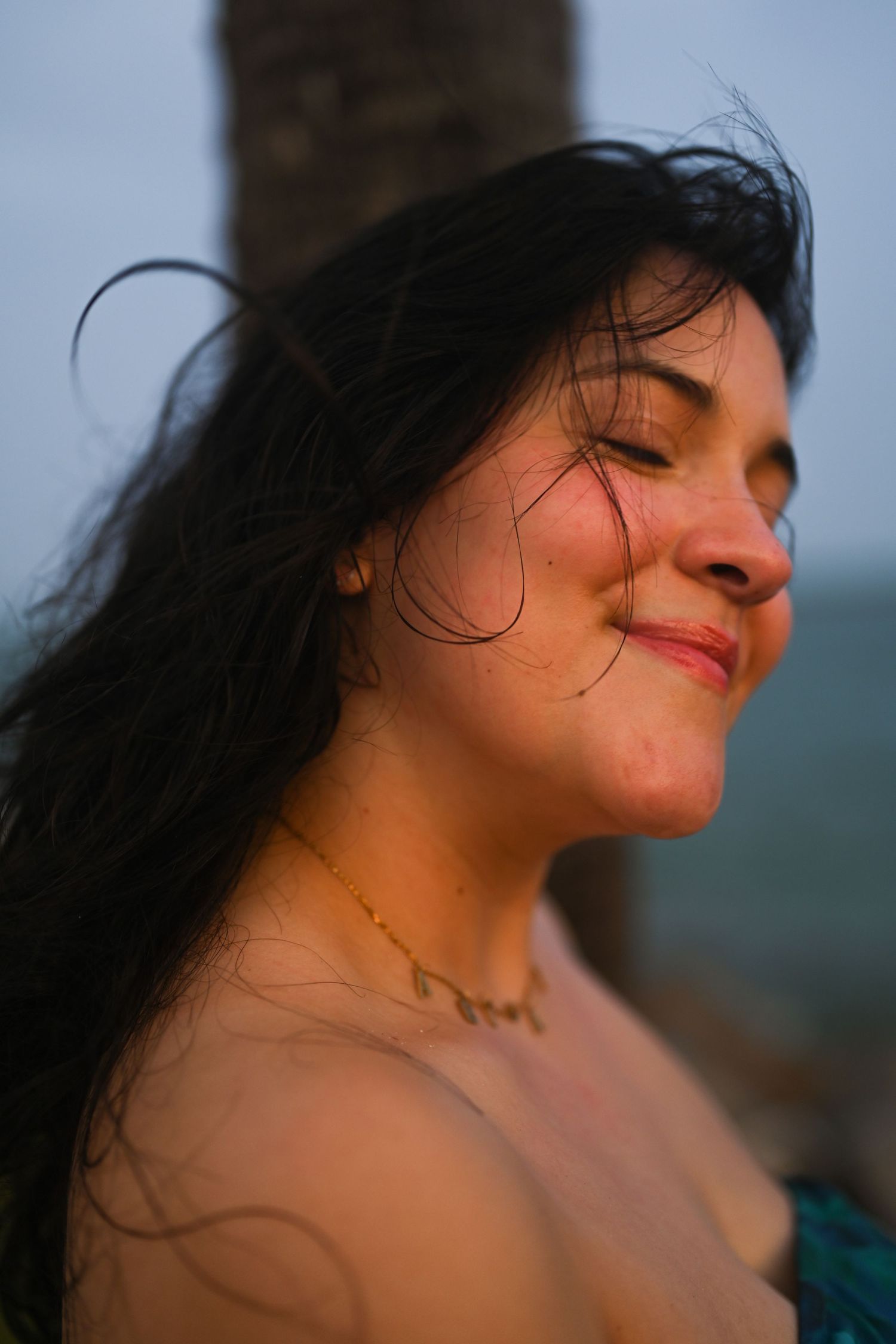 Artistic portrait sequence capturing serene expressions with windswept hair against soft lighting.