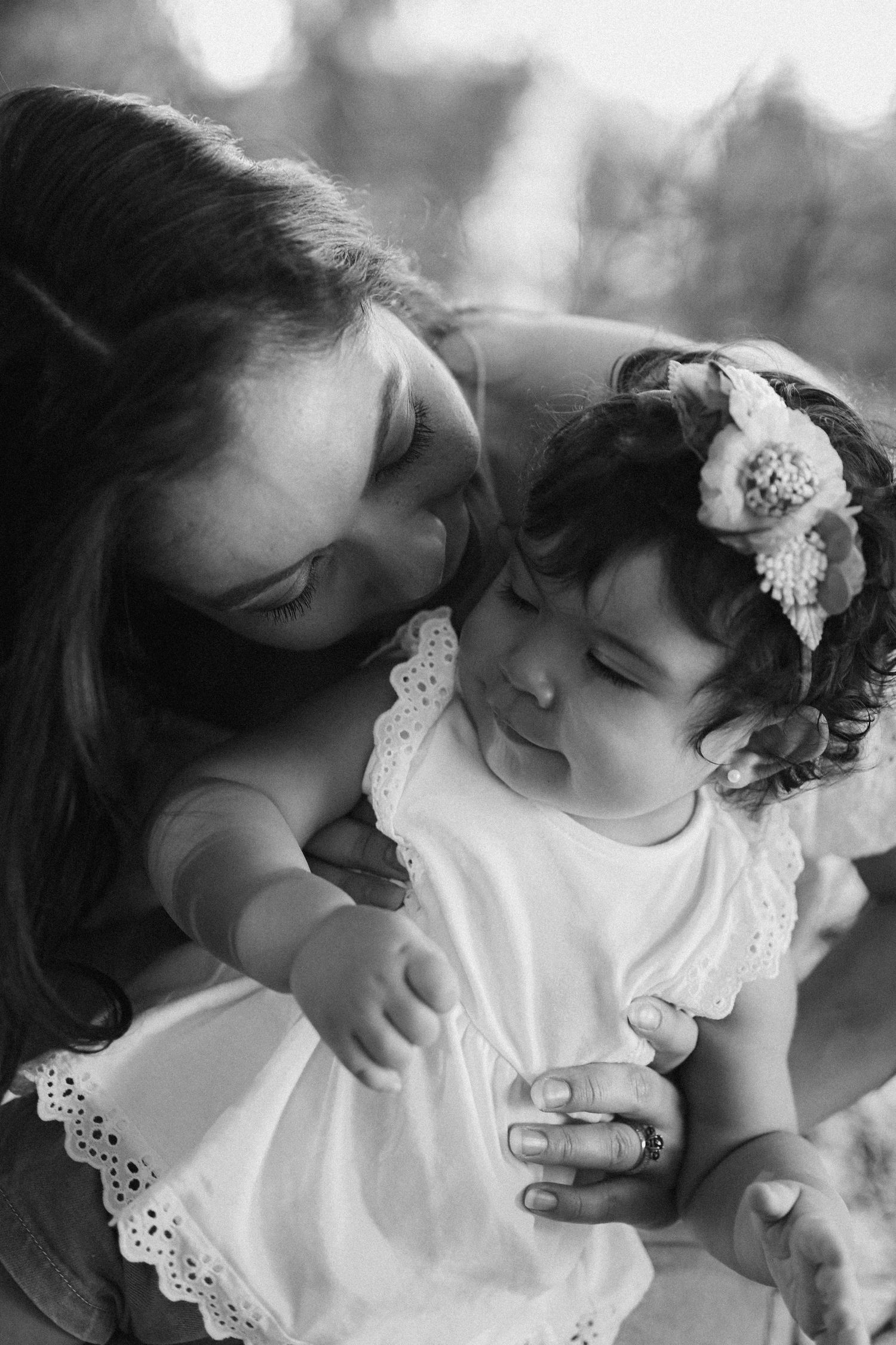 Black and white close-up portrait capturing tender family moment in soft lighting.