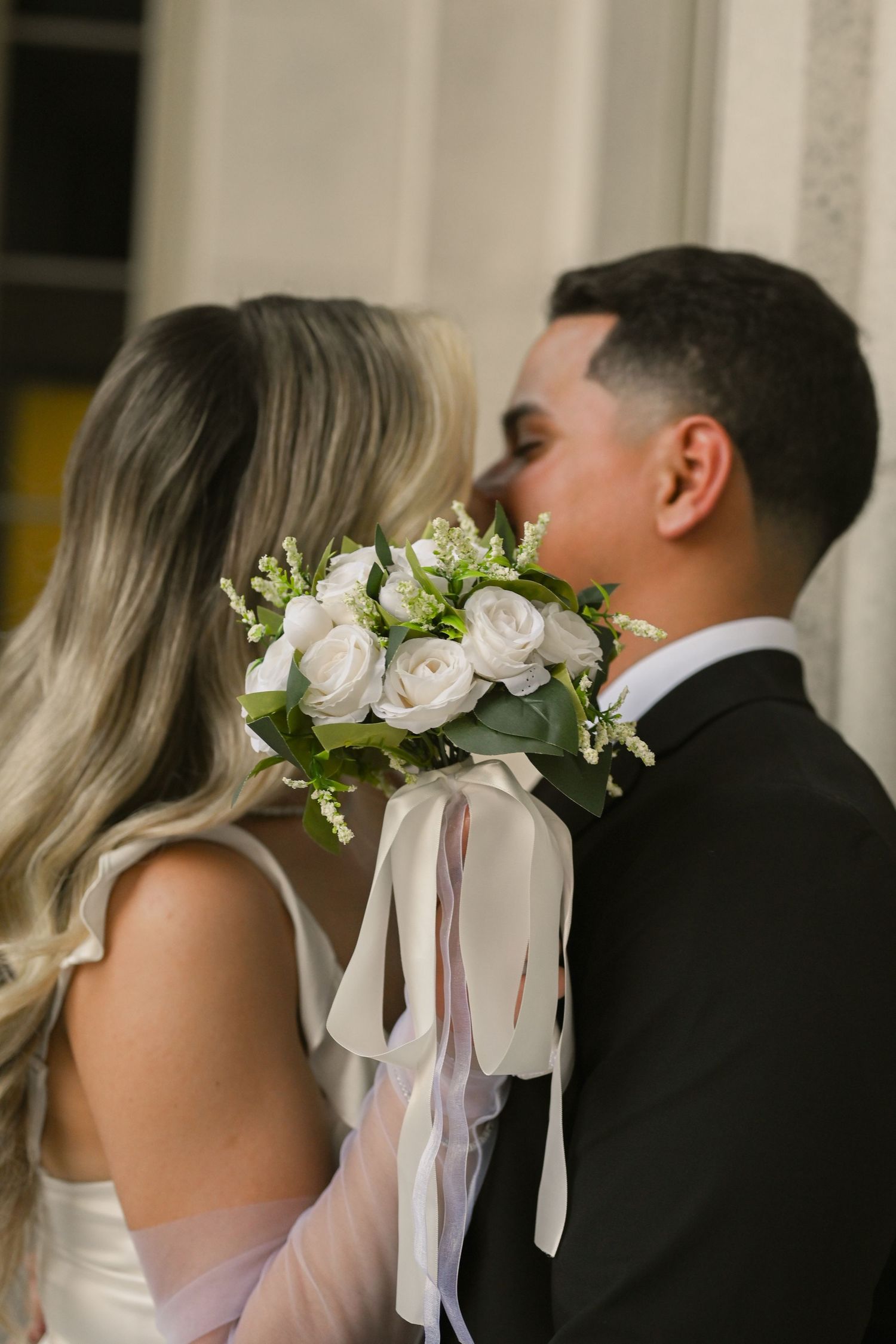 Wedding couple shares intimate moment with floral crown detail.