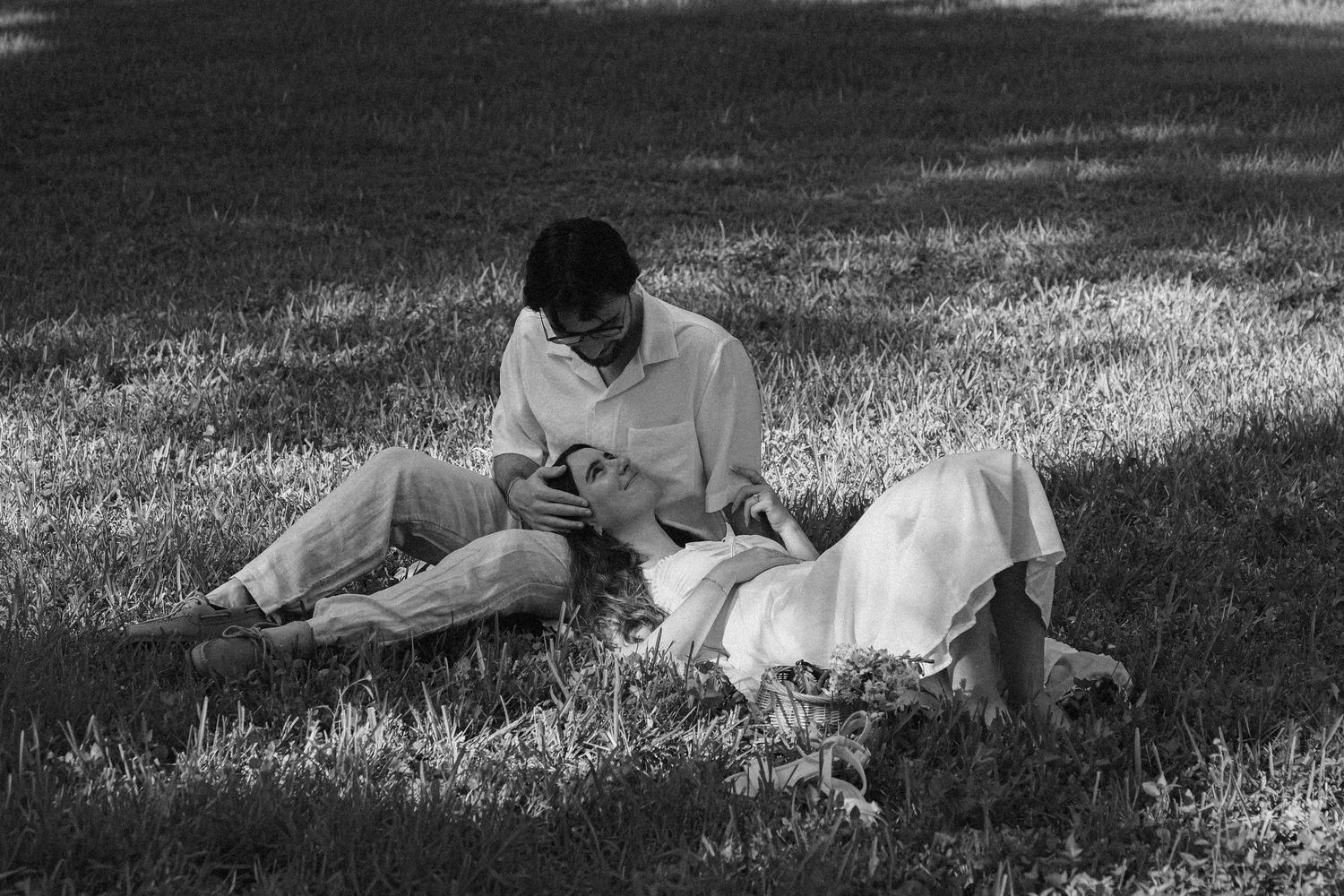 A black and white photo sequence shows a person rolling down a grassy hill in seven progressive frames.