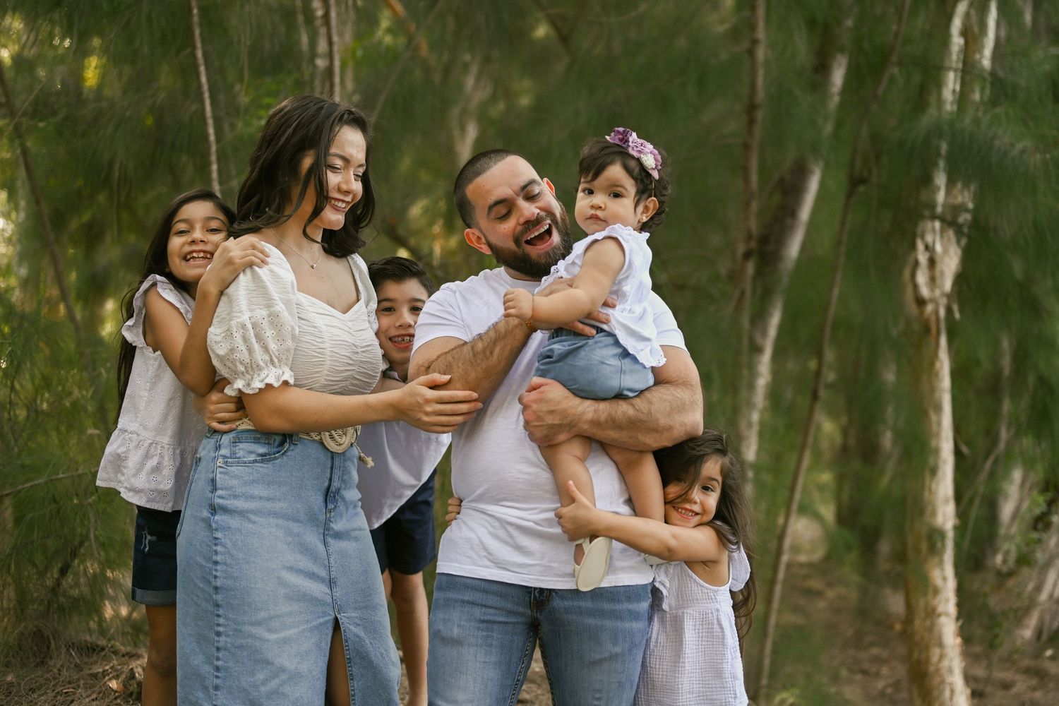 A group shares joyful moments together in a wooded outdoor setting.