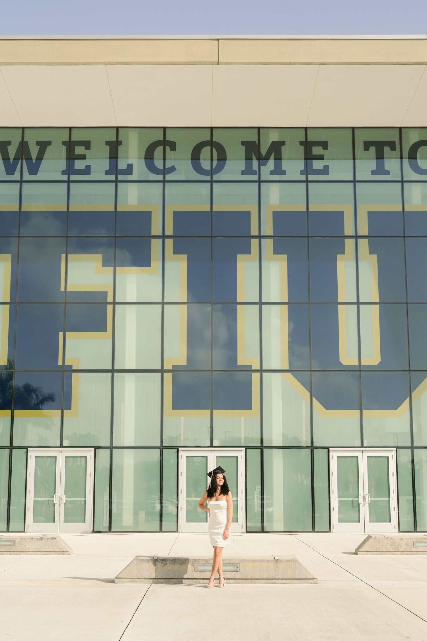 Modern glass building facade with 'WELCOME TO' signage visible.