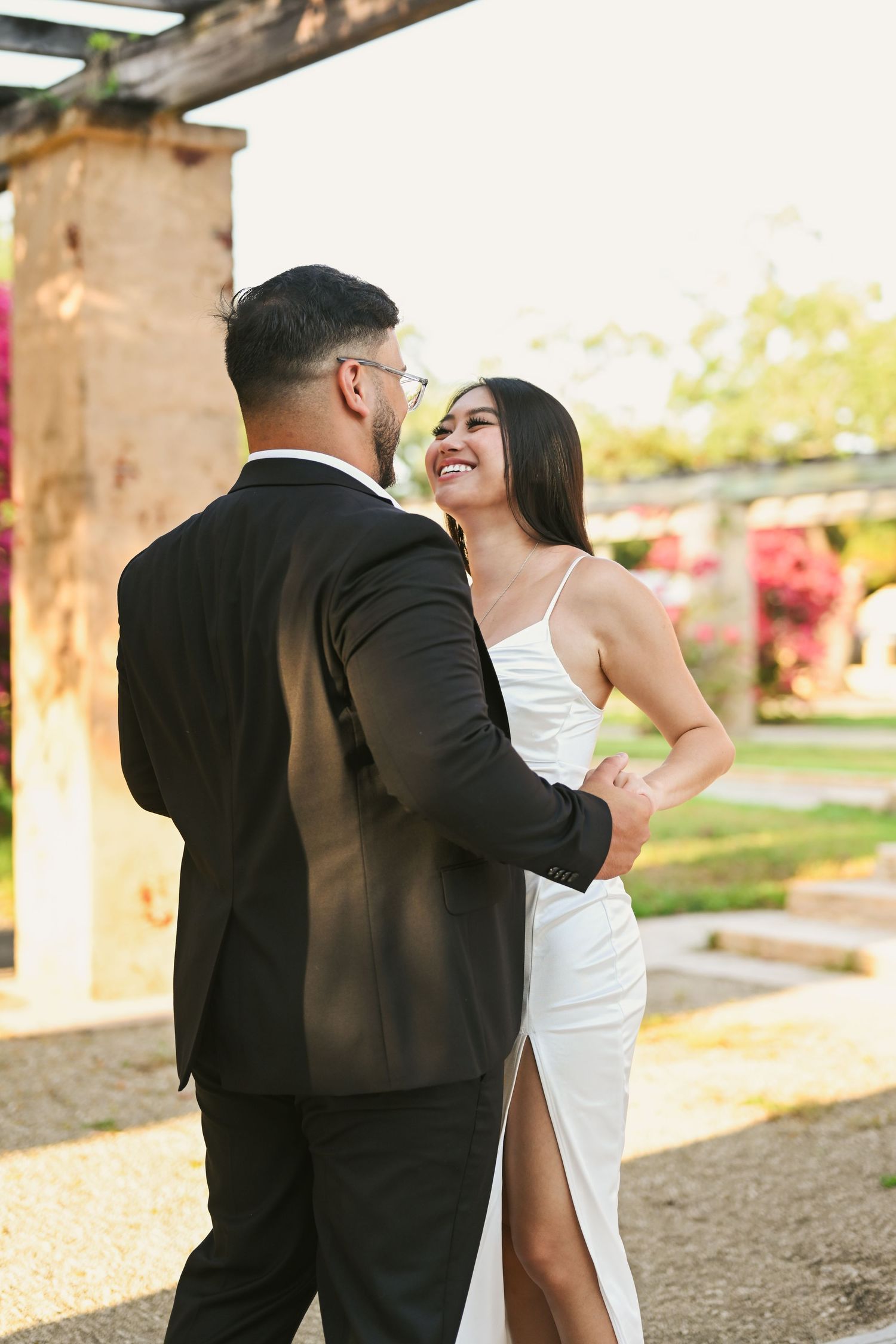 Couple sharing intimate dance moments under stone archways at sunset.