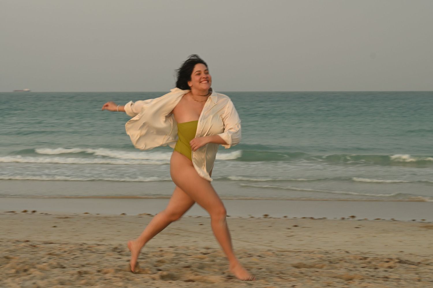 Joyful dance movements on a sandy beach at sunset.