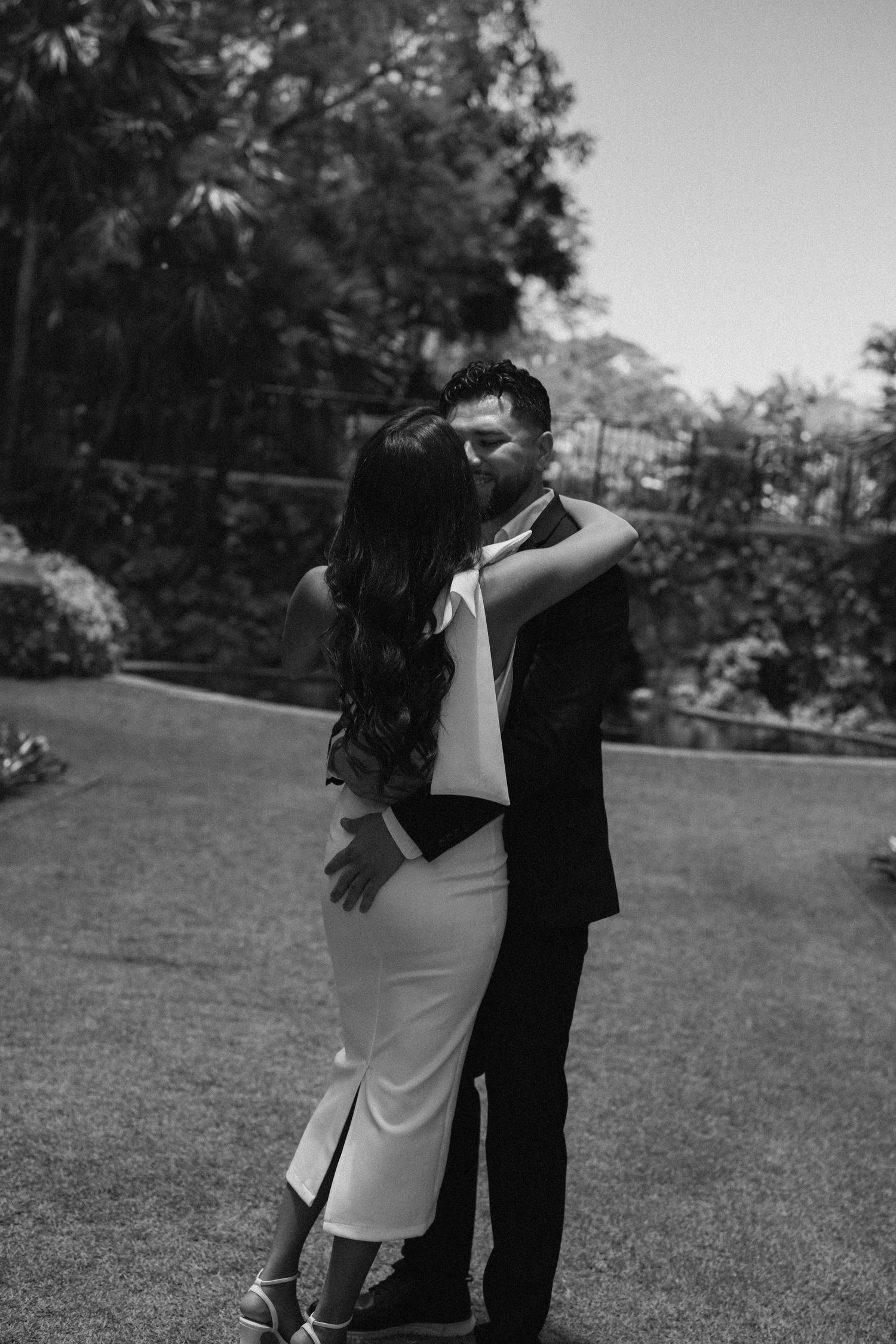 A black and white sequence showing a couple dancing in an outdoor garden setting.