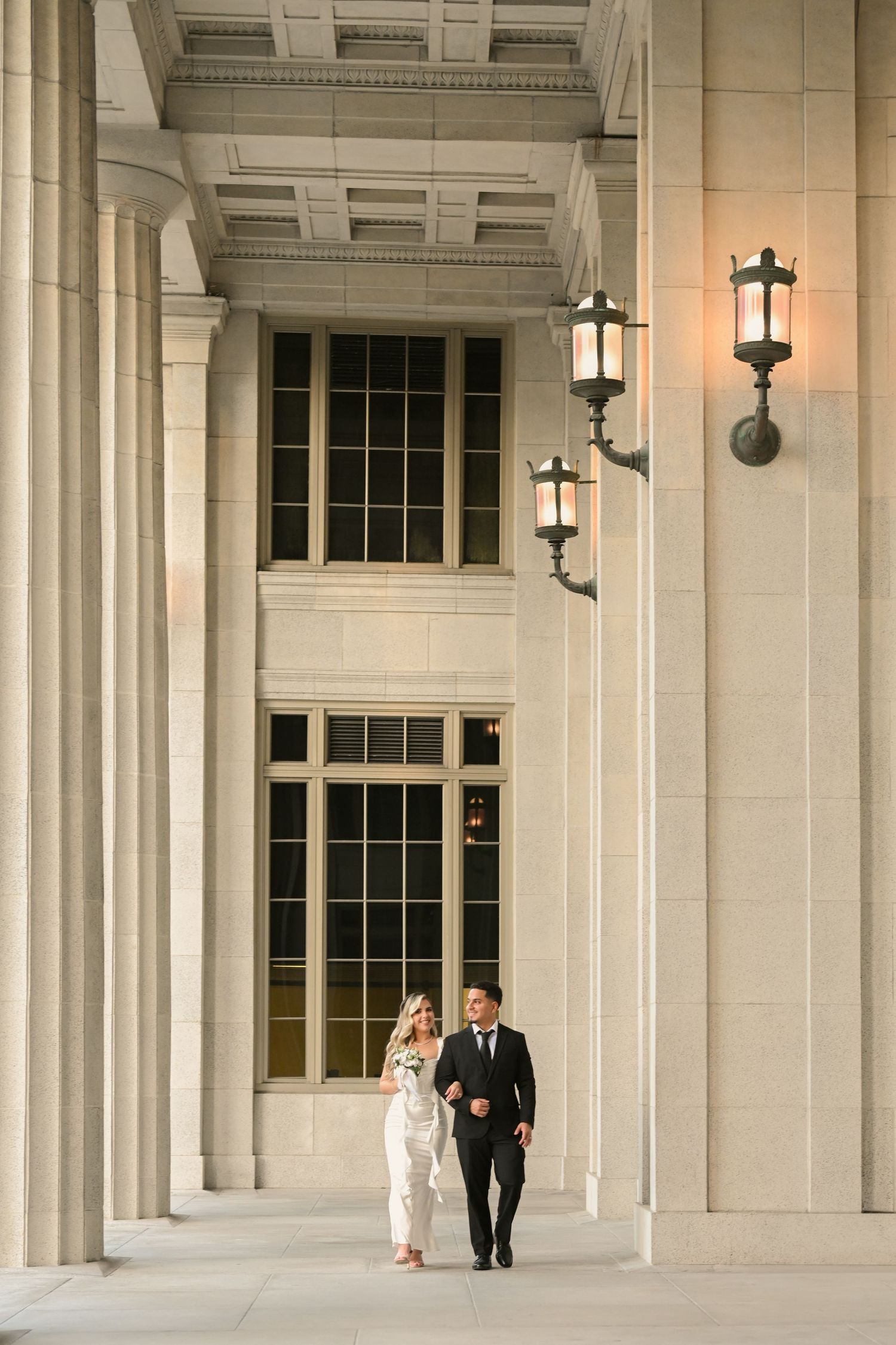 Elegant colonnade with white columns and hanging lanterns creates a grand architectural backdrop at dusk.
