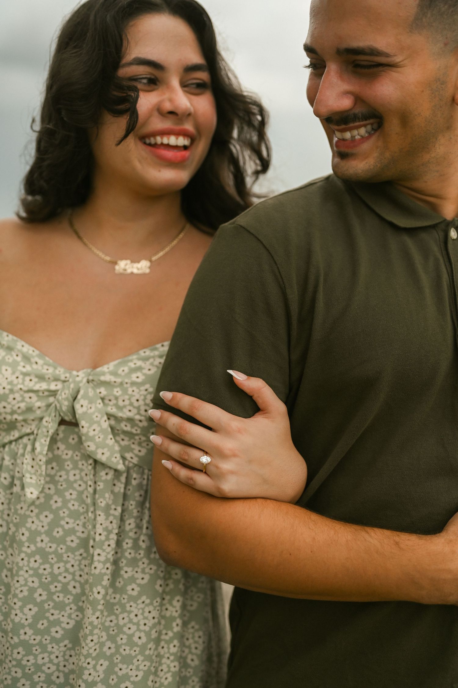 A couple shares intimate laughs while embracing during an outdoor photoshoot.
