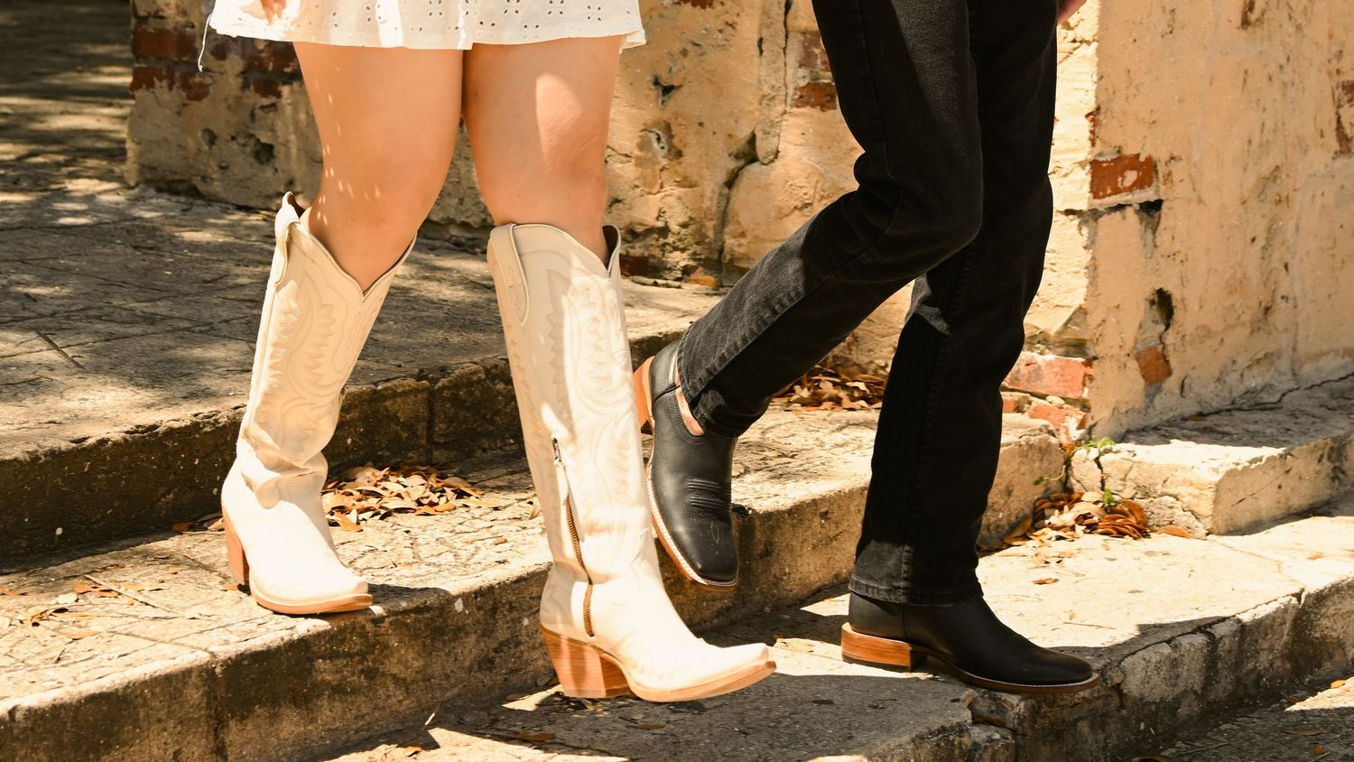 Close-up of feet and shoes on stone architecture detail.