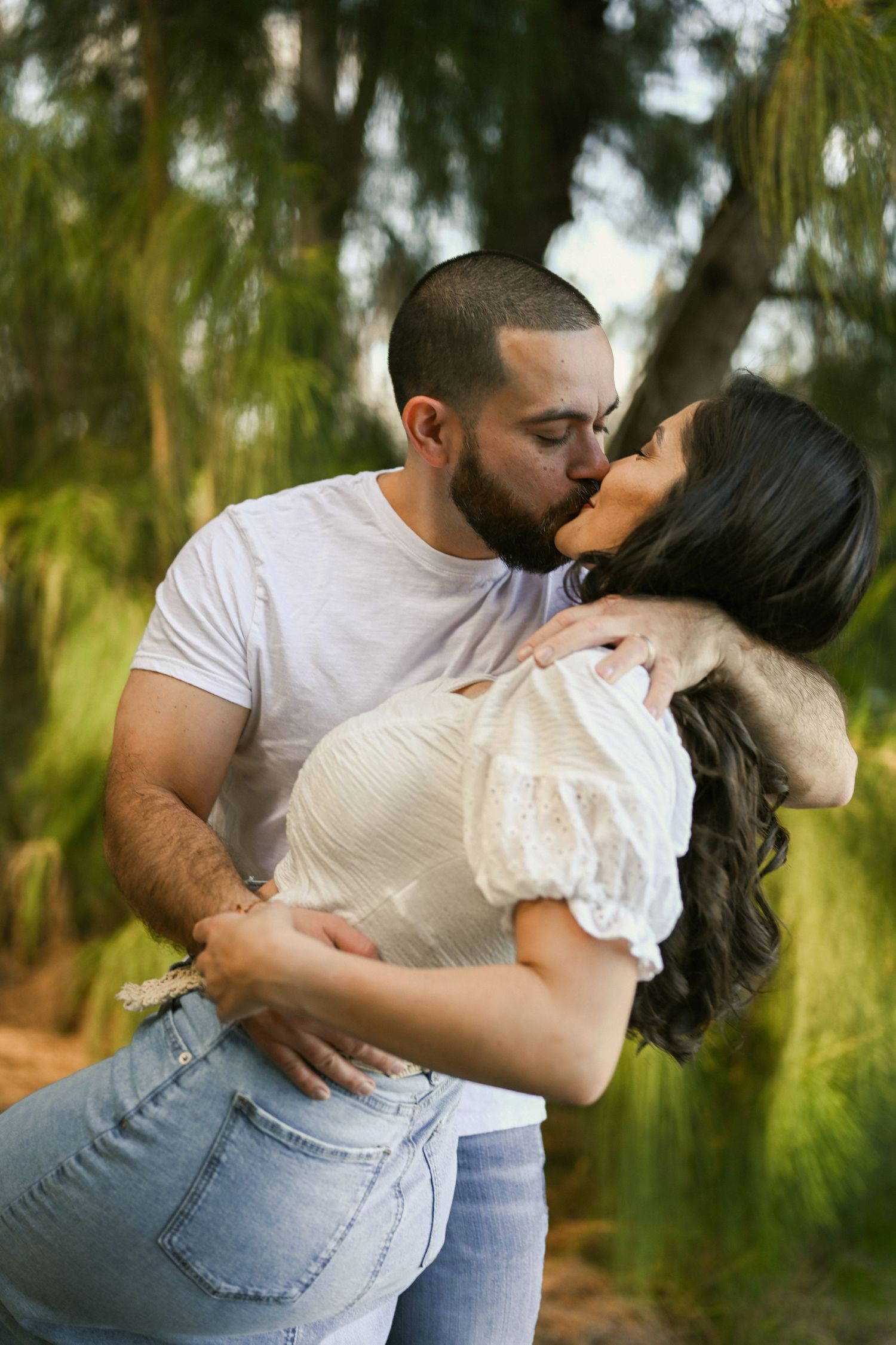 A couple shares affectionate moments in a series of intimate outdoor photos.