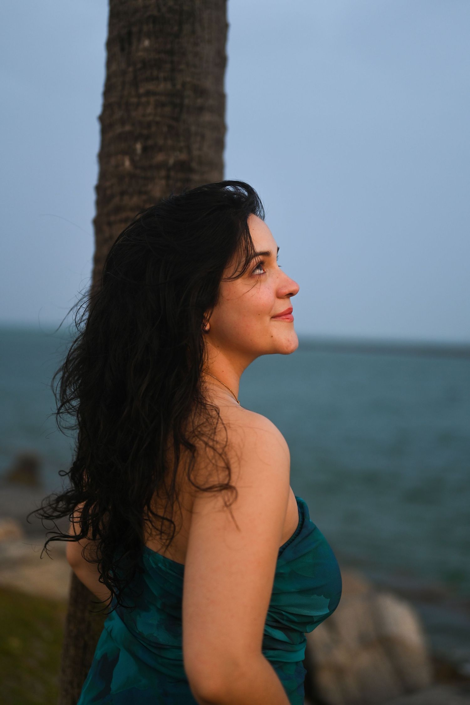 Profile portraits against ocean backdrop with wind-swept hair.