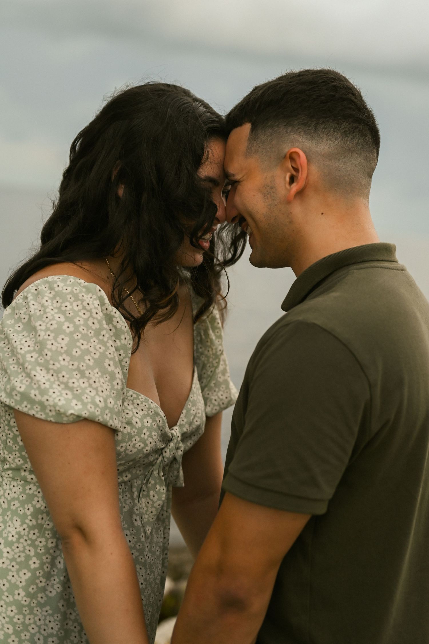 A couple shares intimate moments during their coastal engagement photoshoot.
