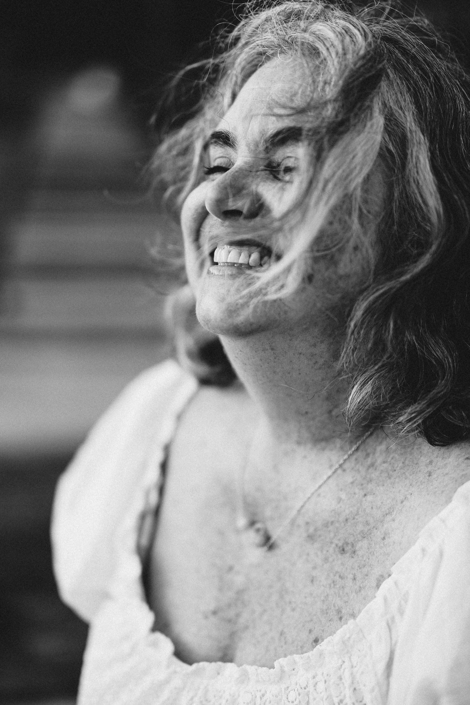 A series of black and white cropped profile shots showing someone wearing white and laughing joyfully.