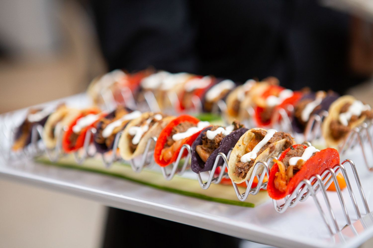 Artistic sushi roll presentation with colorful toppings and drizzled sauce on a white plate.