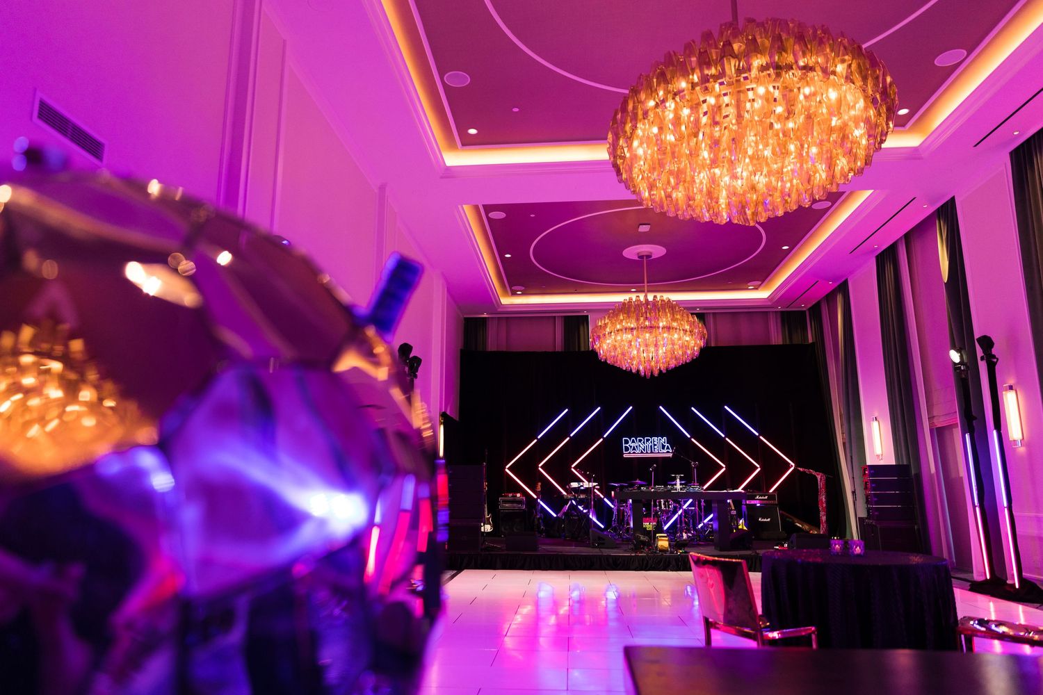 Glamorous ballroom with purple lighting and crystal chandeliers creating a dramatic atmosphere.