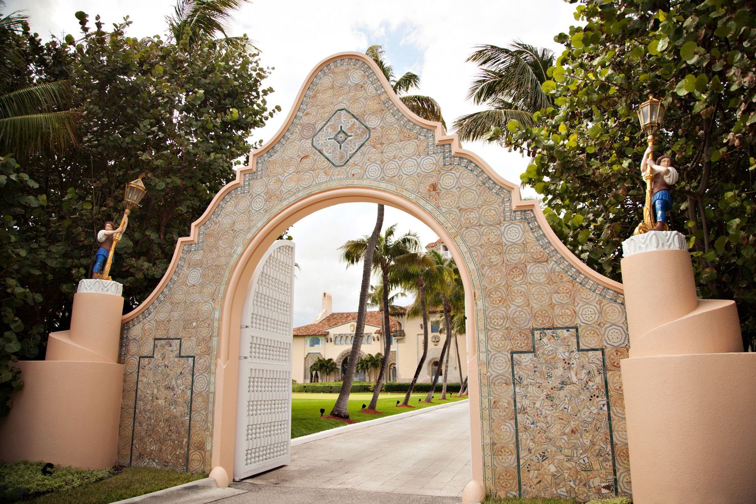 Decorative stone archway entrance with palm trees and architectural details.