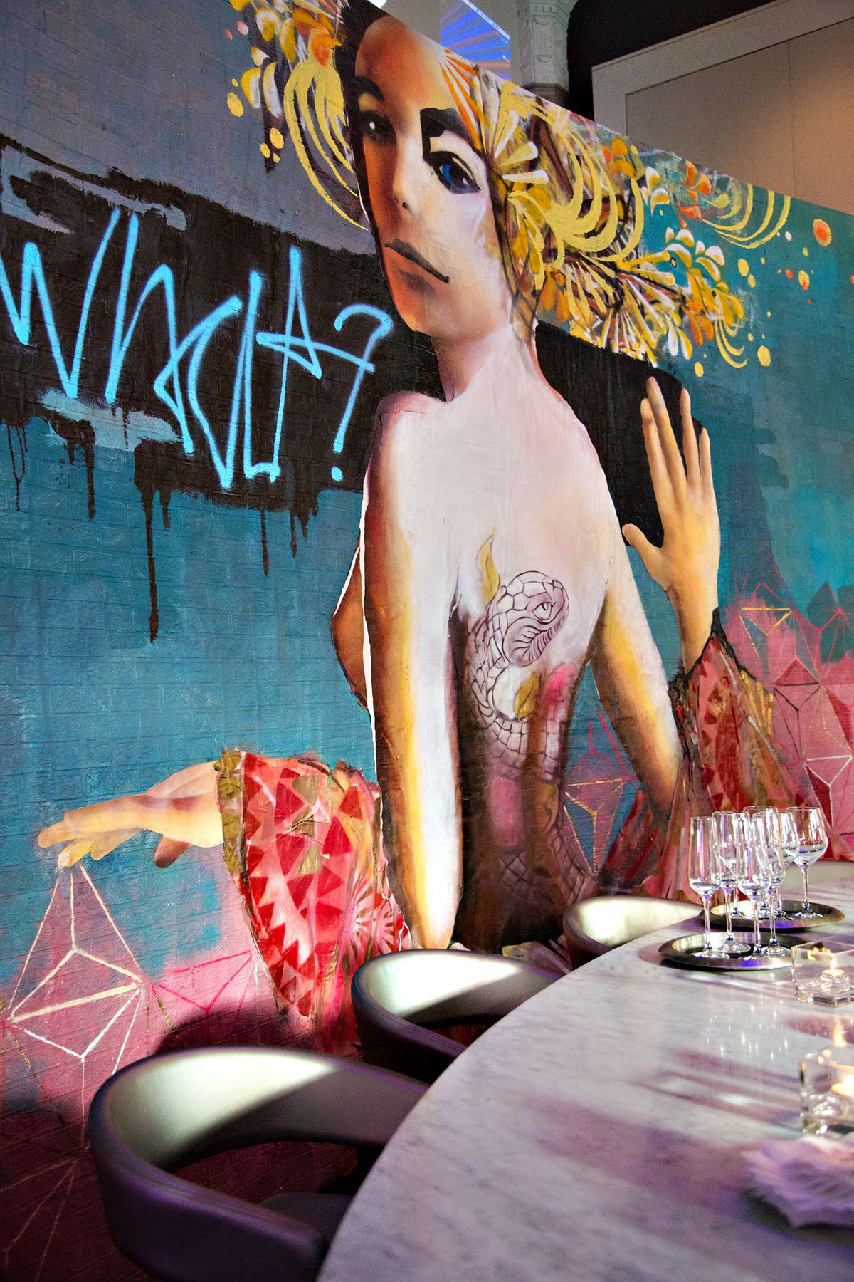 Artistic mural featuring stylized female figure with geometric decorative elements.