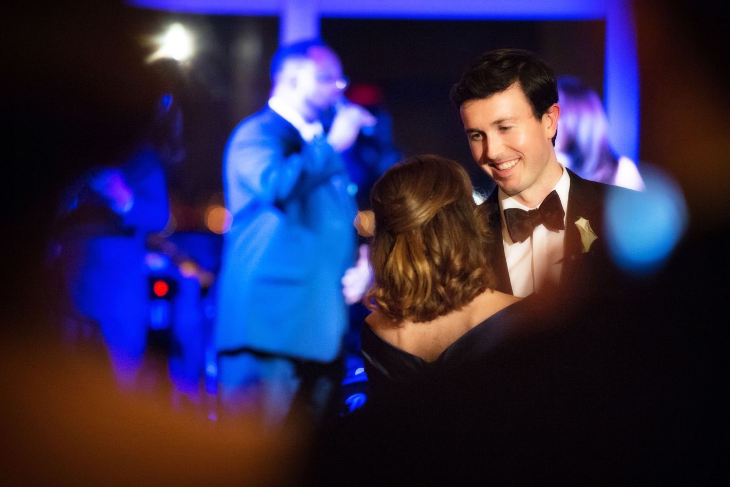 A series of dance photos at a wedding reception illuminated by blue lighting and bokeh effects.