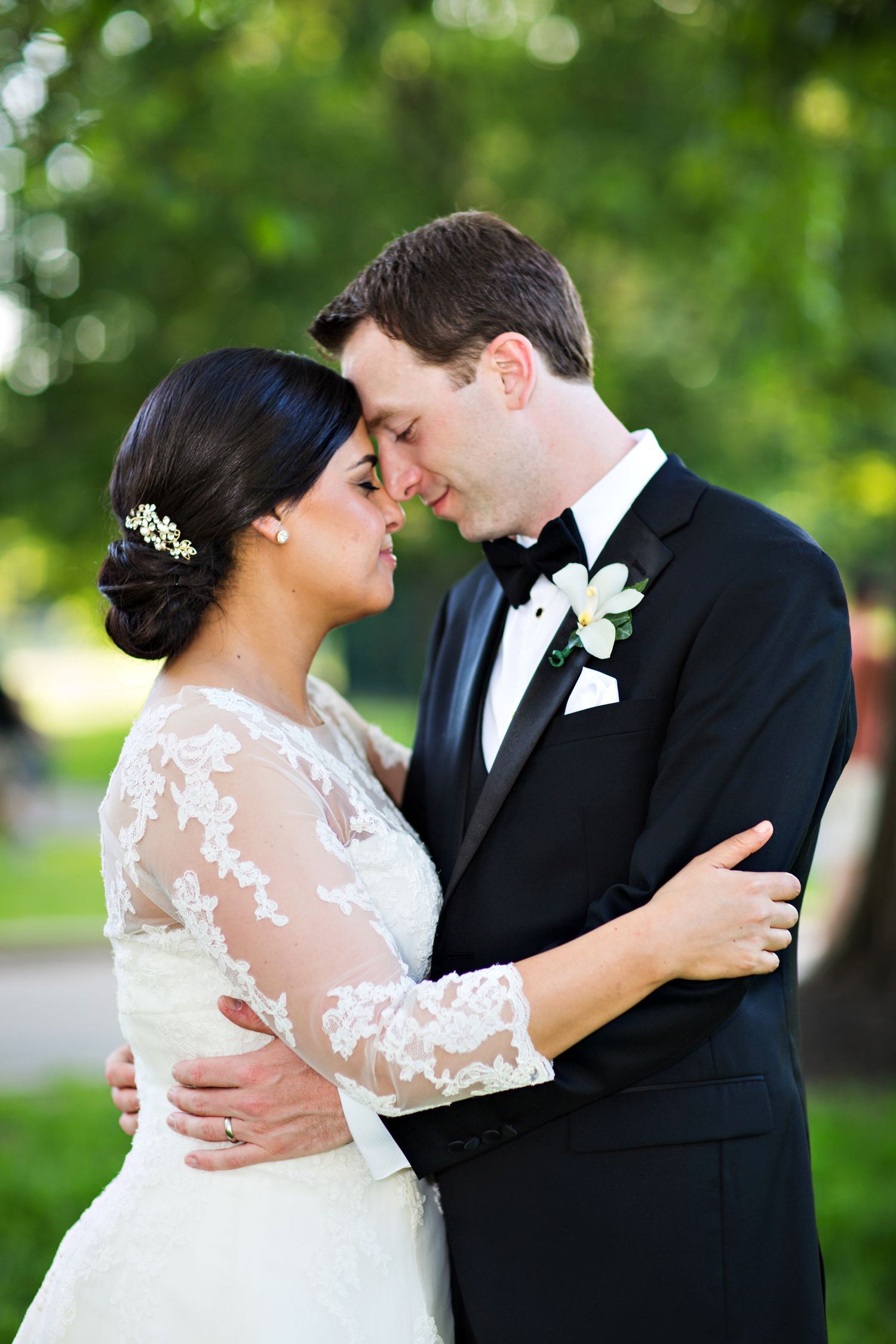A romantic wedding couple shares intimate moments in a garden setting with soft bokeh background lighting.