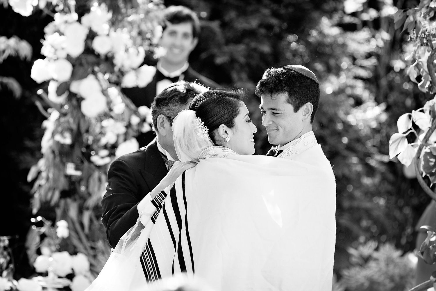 A black and white wedding photo collage showing intimate moments between the couple during their outdoor ceremony.