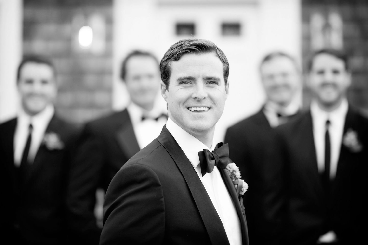 A black and white collage of wedding party photos showing groomsmen in formal tuxedos and bow ties.