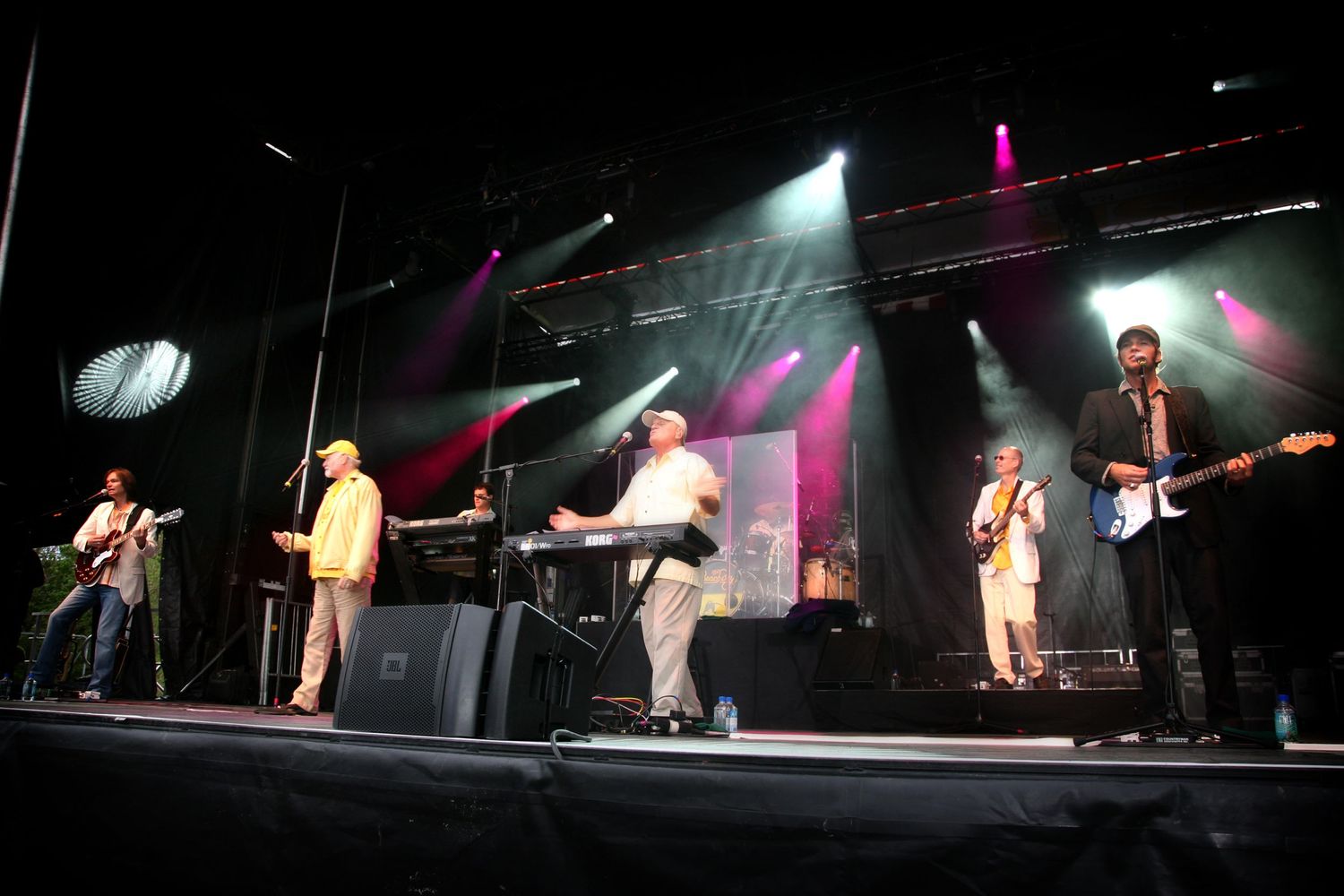 Band performing live on stage with dramatic concert lighting and effects.