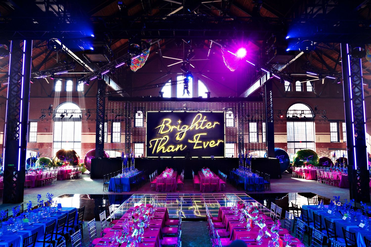 Elegant event space with neon signage and blue lighting creating dramatic atmosphere.