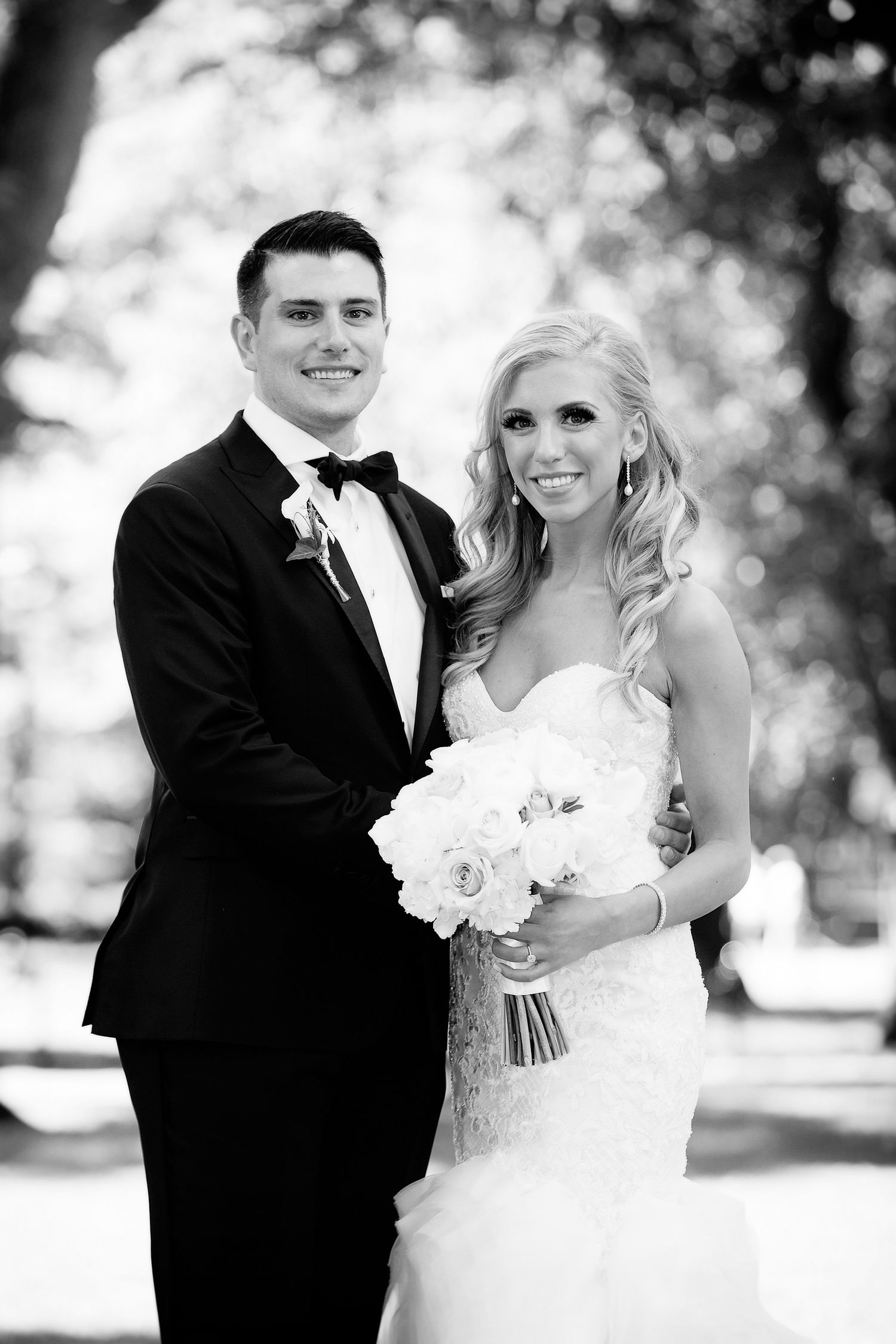 Classic black and white wedding portrait with bride holding a white rose bouquet.